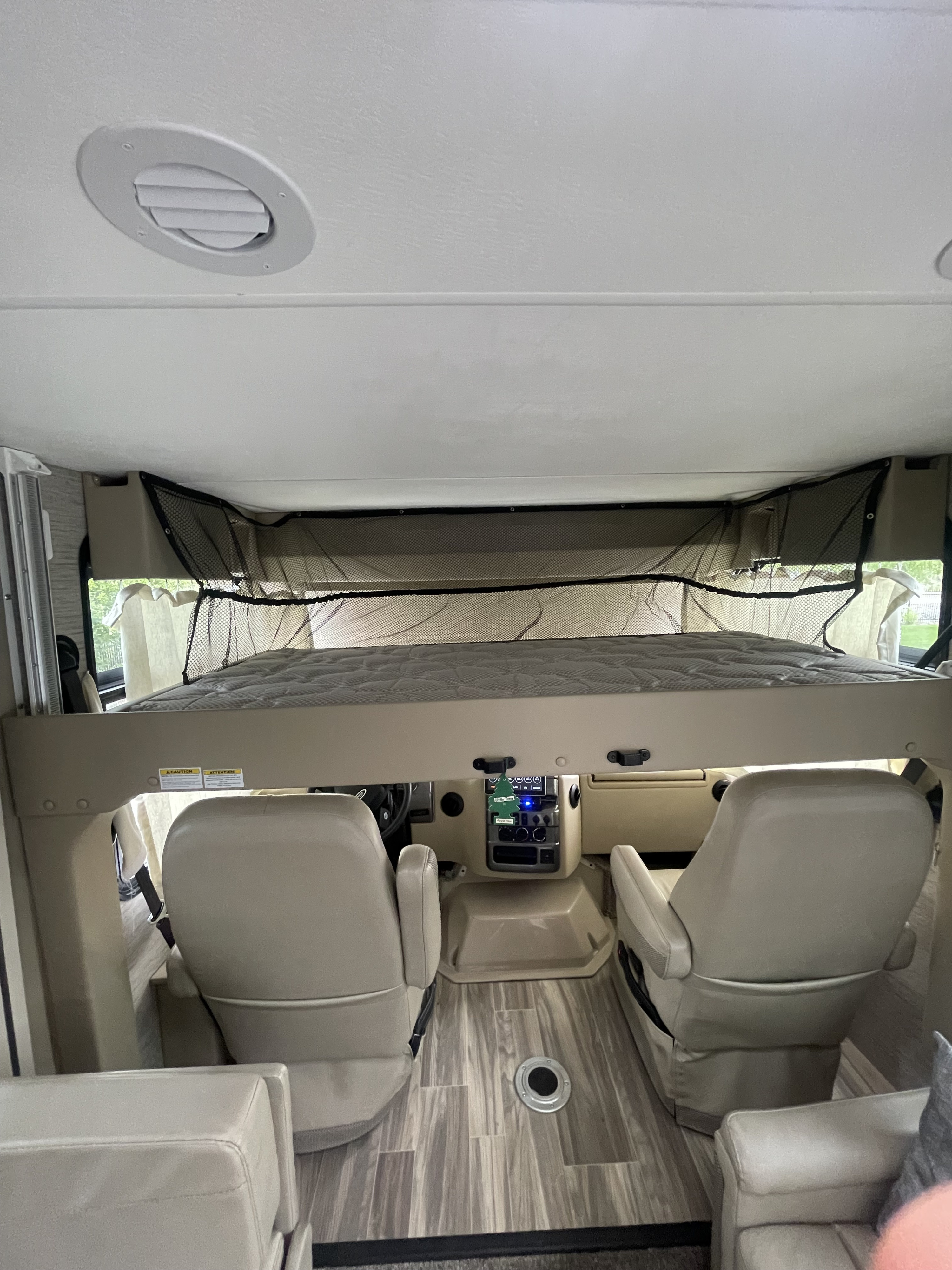 Inside this RV rental, see the cab-over bed, driver's cockpit, and passenger seating area. A practical motorhome interior.. Thor Motor Coach Vegas 2022