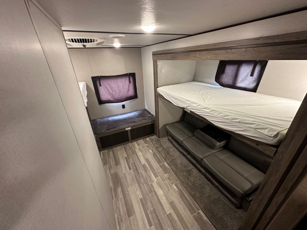RV rental interior with cozy bunk beds & sofa lounge. This spacious bunkhouse setup is perfect for family adventures.. Crossroads 328SB 2020