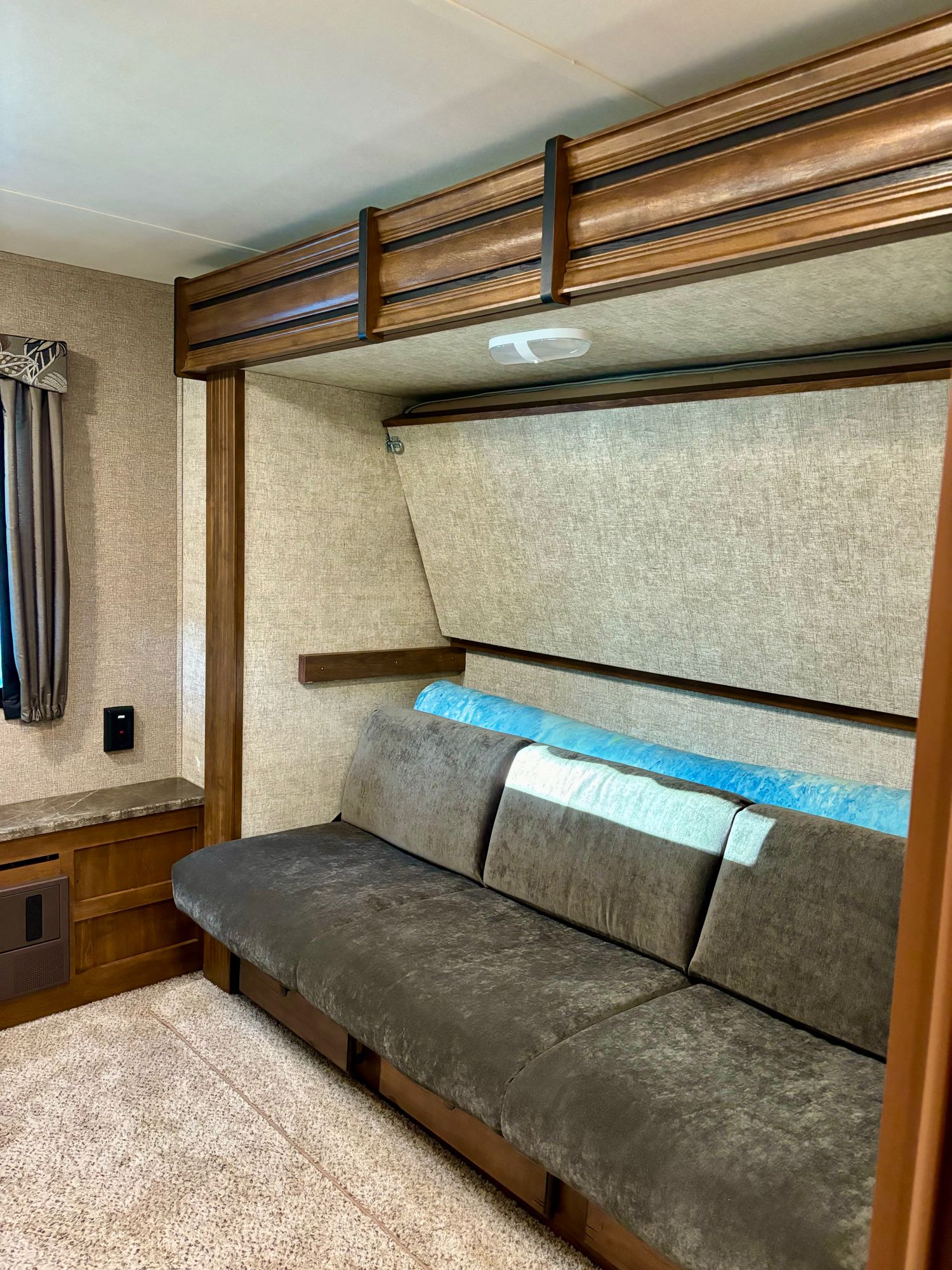 Inside an RV rental: A cozy living area with a sofa that transforms into a bunk bed, perfect for guests.. Keystone RV Sprinter Campfire Edition 2015