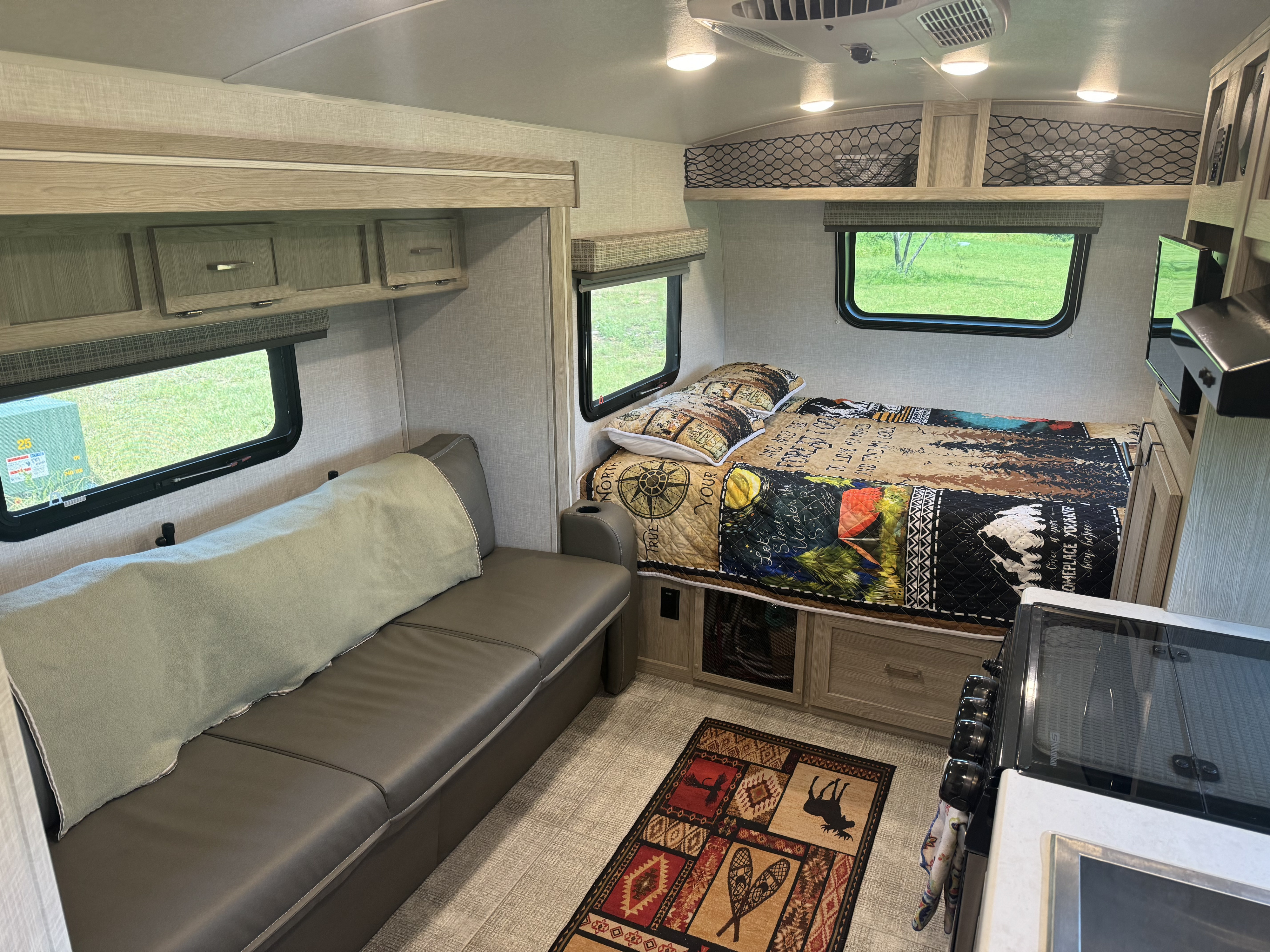 Cozy interior of an rv rental featuring a bed, sofa, and kitchen amenities, perfect for camping trips.. Forest River Flagstaff E-Pro 2020