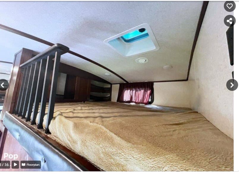 RV rental: Cozy elevated bed (loft/bunk) with railing, window, & ceiling vent in an RV interior.. Jayco Pinnacle 2018