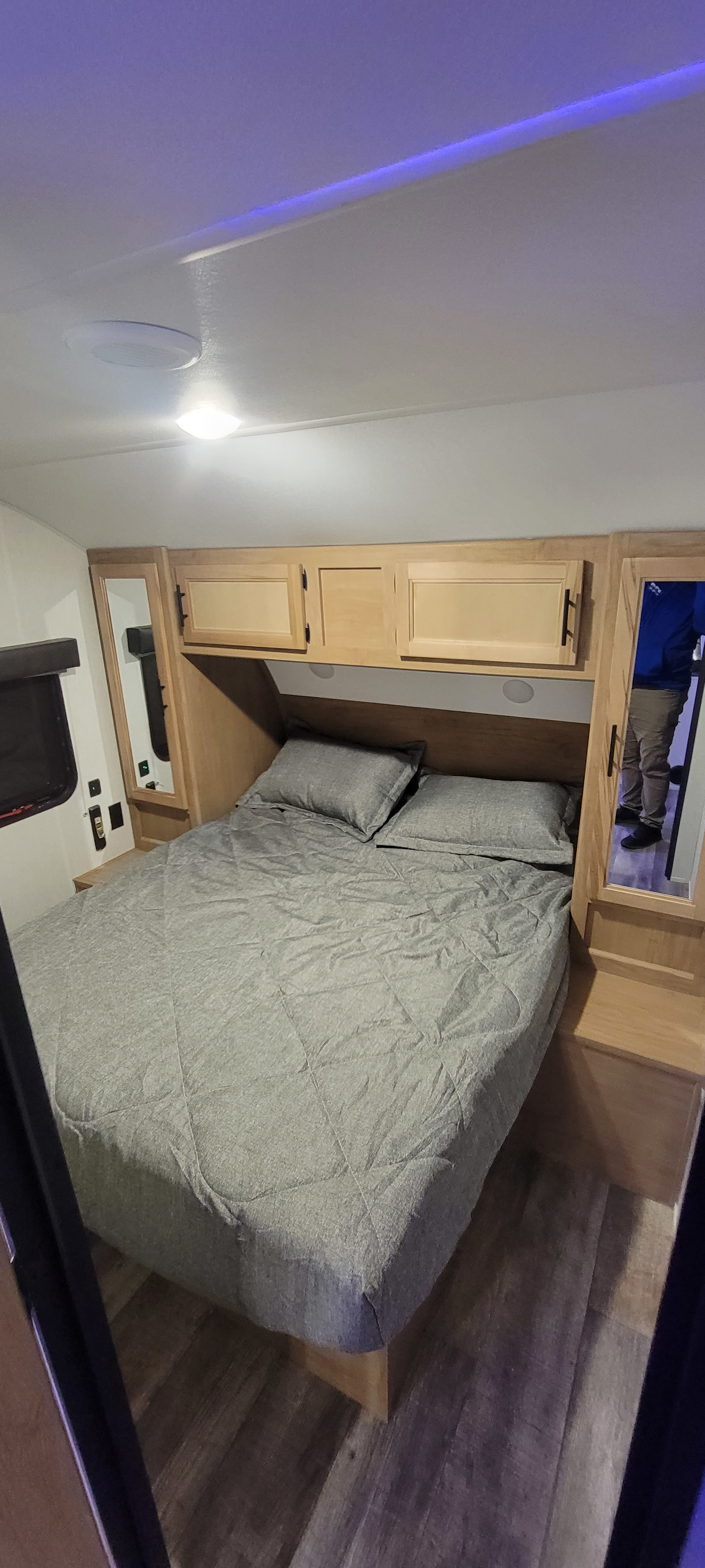 Modern RV rental bedroom featuring a comfy bed, overhead storage, and sleek lighting.. Forest River Cherokee Grey Wolf 2023