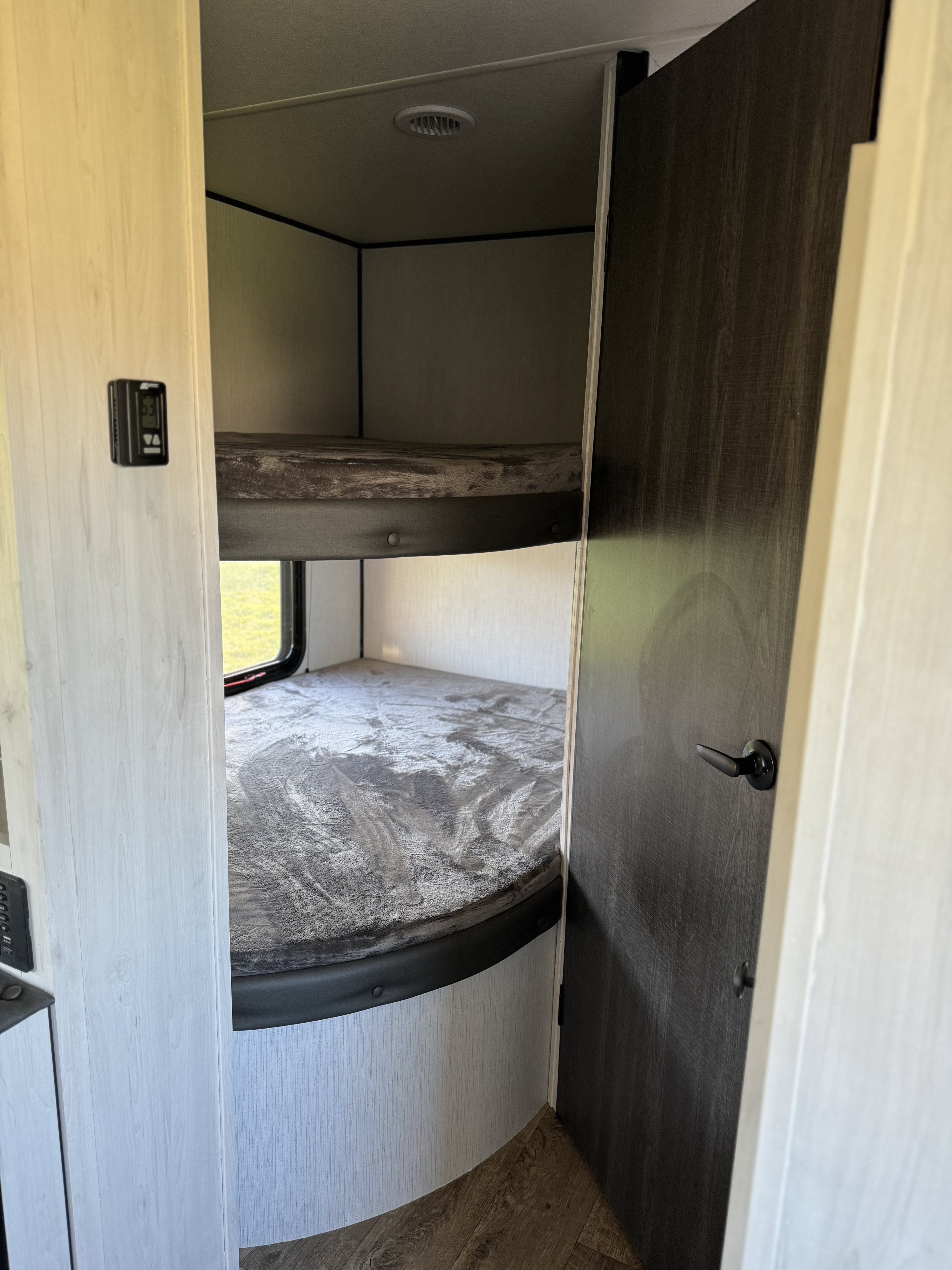 RV rental: view of cozy bunk beds. Features an upper and lower sleeping area, window, and interior door.. Heartland RVs Trail Runner 2023