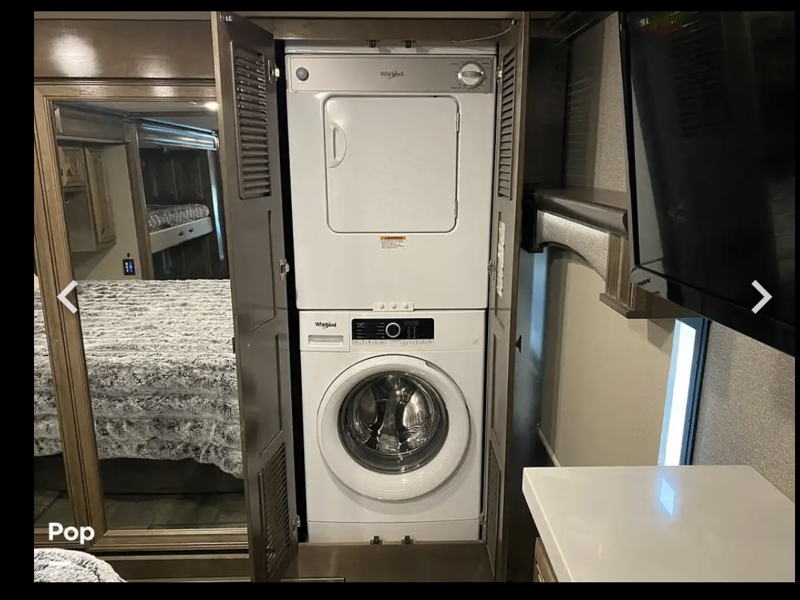 Compact stacked Whirlpool washer and dryer in this RV rental, providing convenient laundry solutions on the go.. Fleetwood Discovery LXE 2020