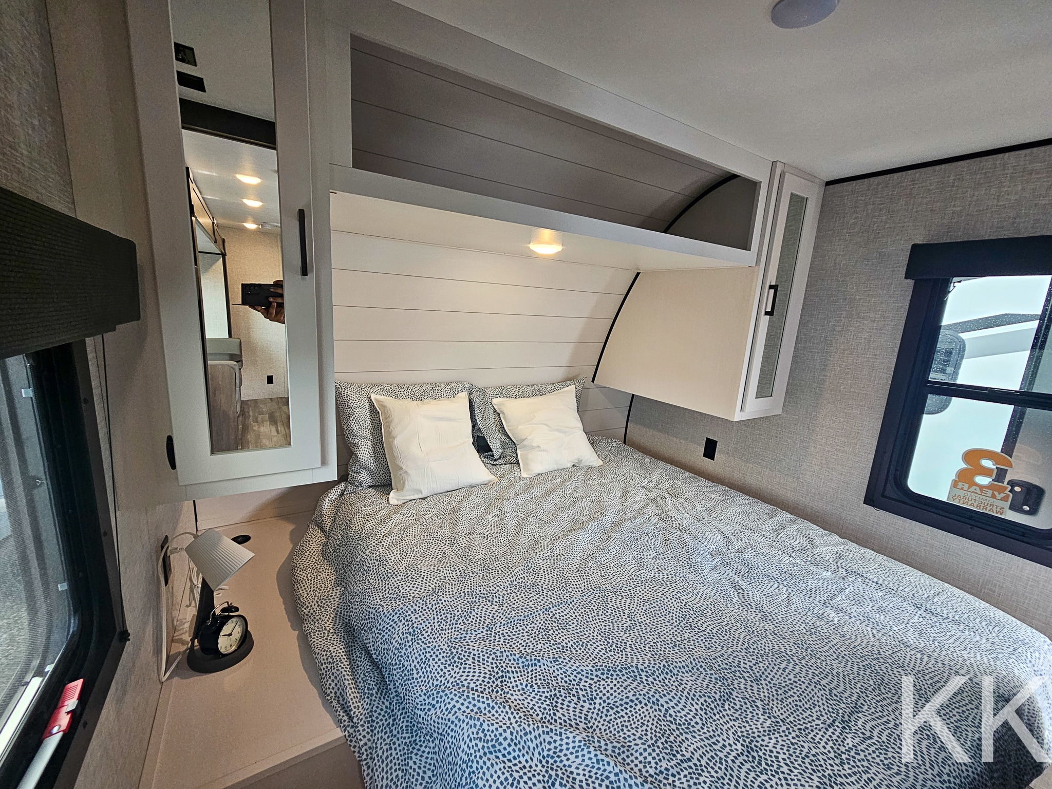 This RV rental's inviting bedroom offers a comfortable bed, ample storage, and mirrored closet for your adventures.. Highland Ridge RV Open Range 2024