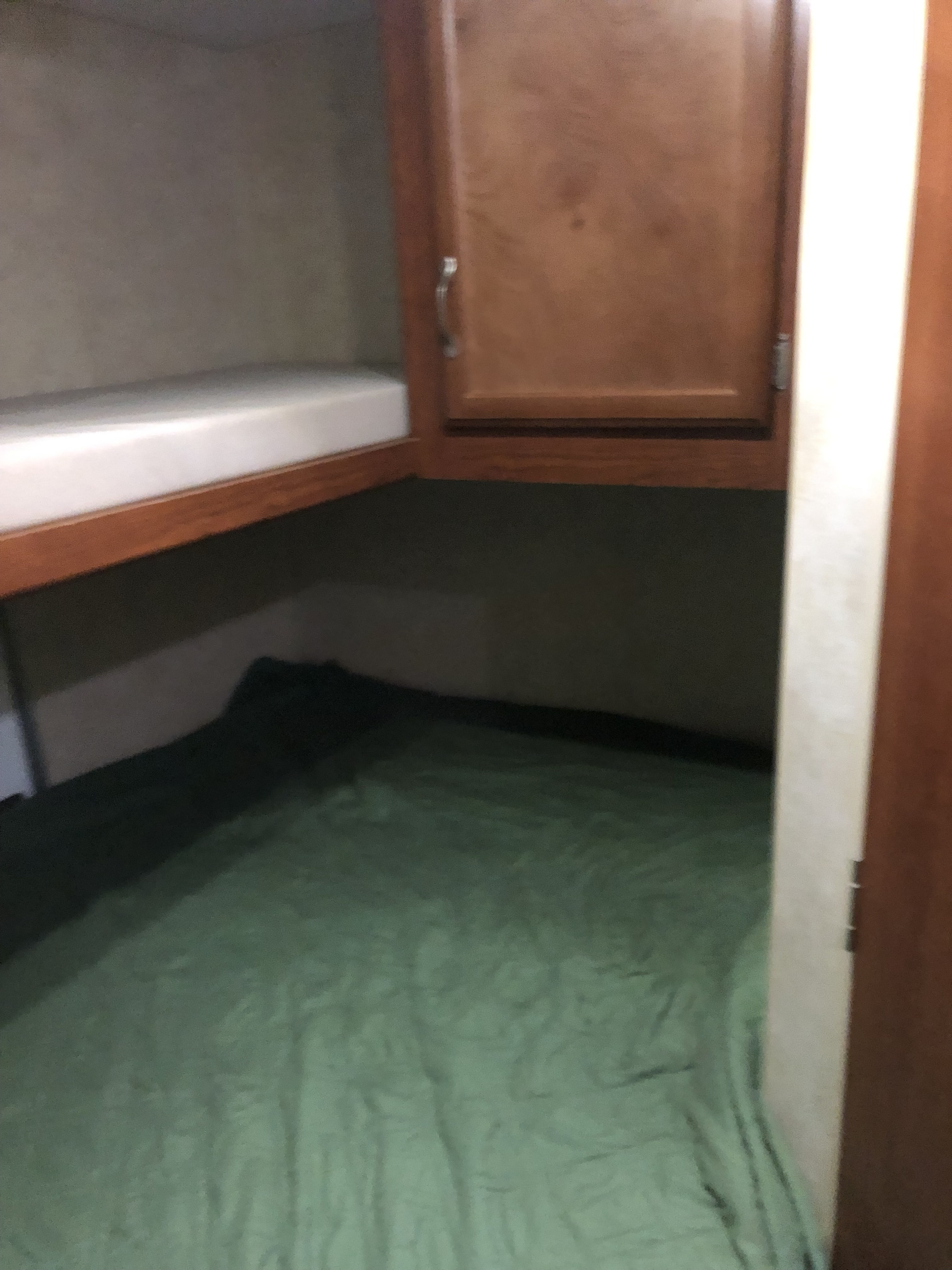 RV rental interior featuring bunk beds, a wooden cabinet, and a lower green sleeping area, perfect for camping trips.. Outdoors RV Timber Ridge 2011