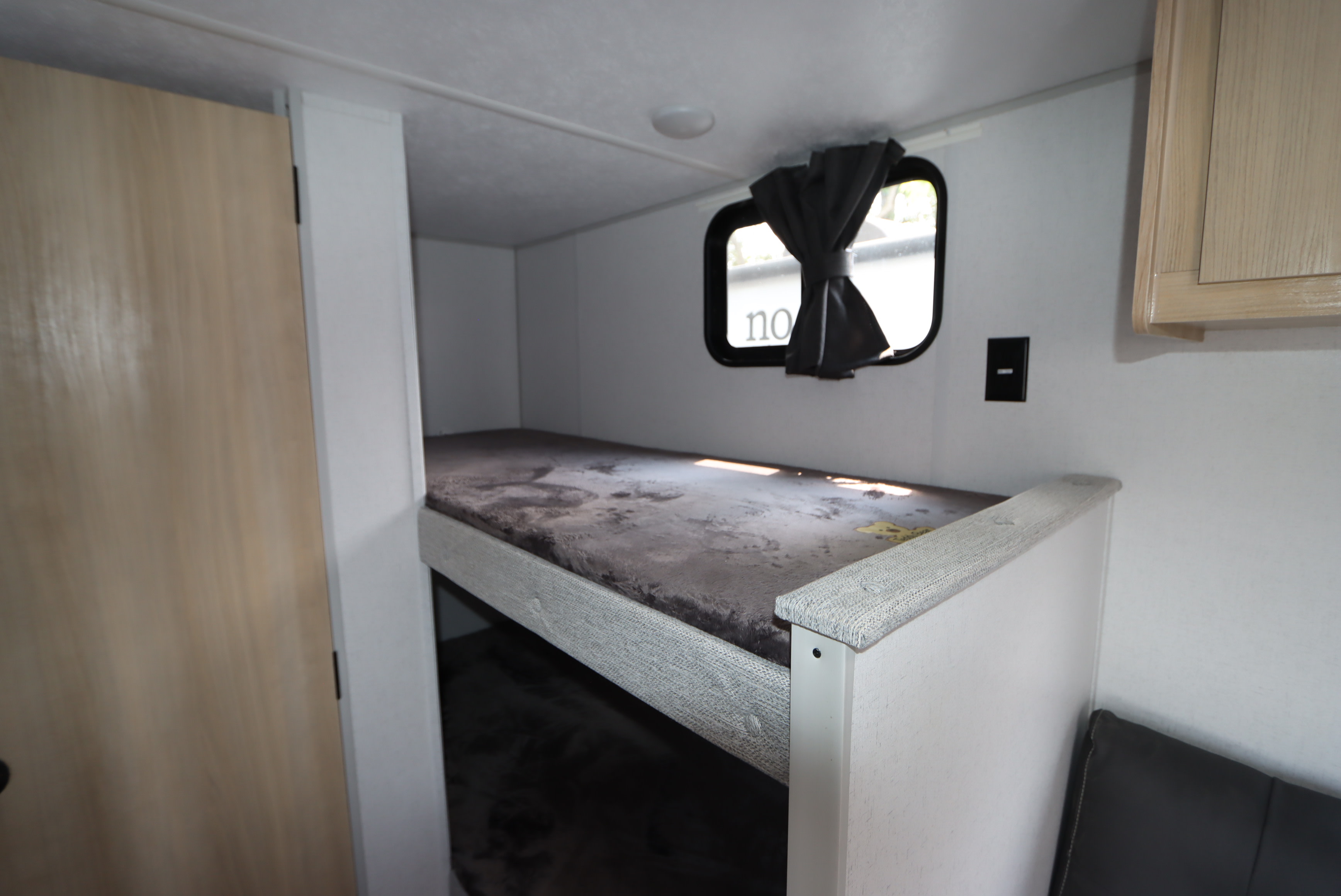 RV rental: Interior bunk beds with light gray bedding in this compact travel trailer, featuring a window and light wood door.. Forest River Salem 2024