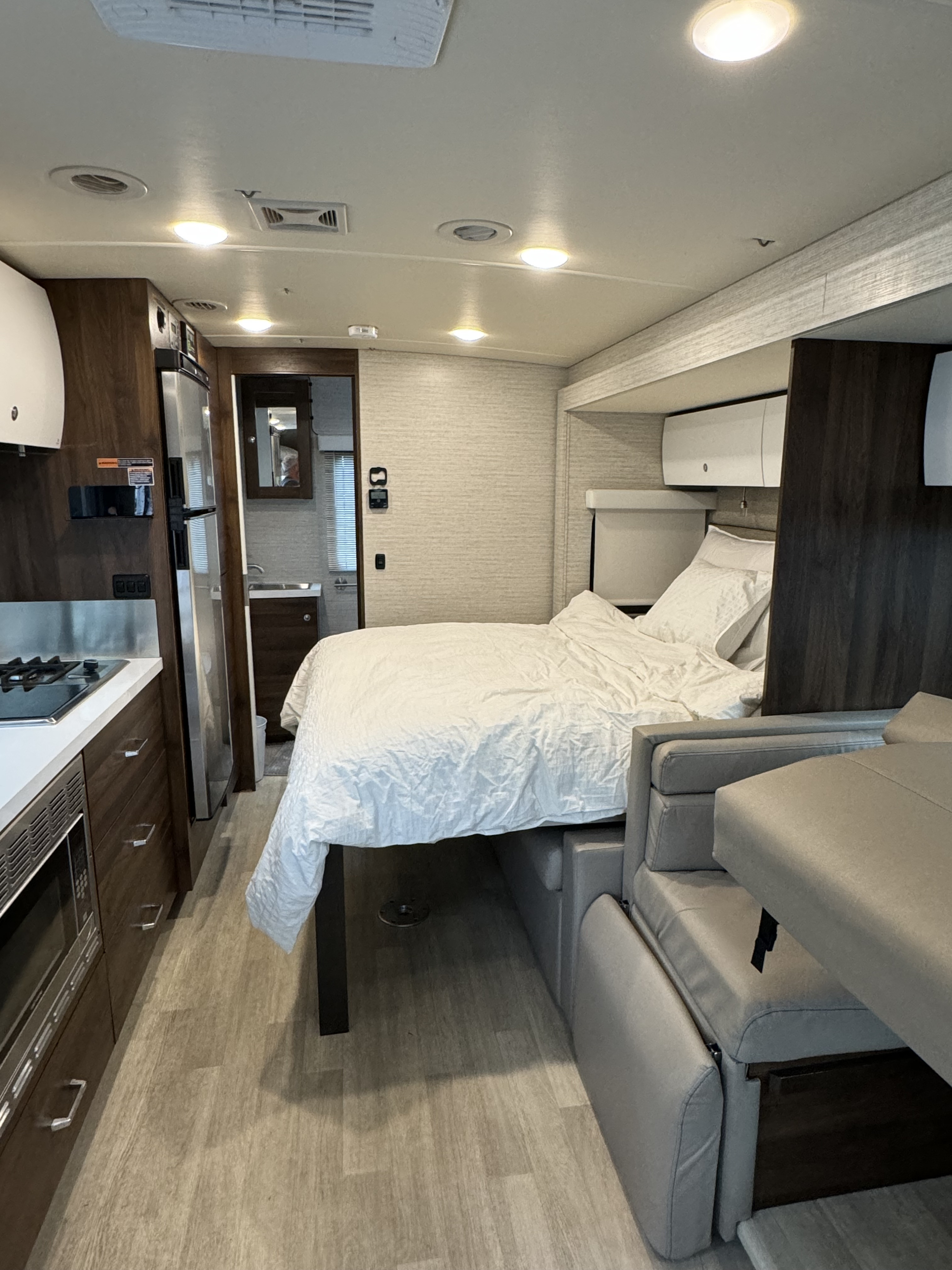 Modern rv rental interior featuring a cozy bedroom, compact kitchen, and living area in a mobile setting.. Winnebago View 2022