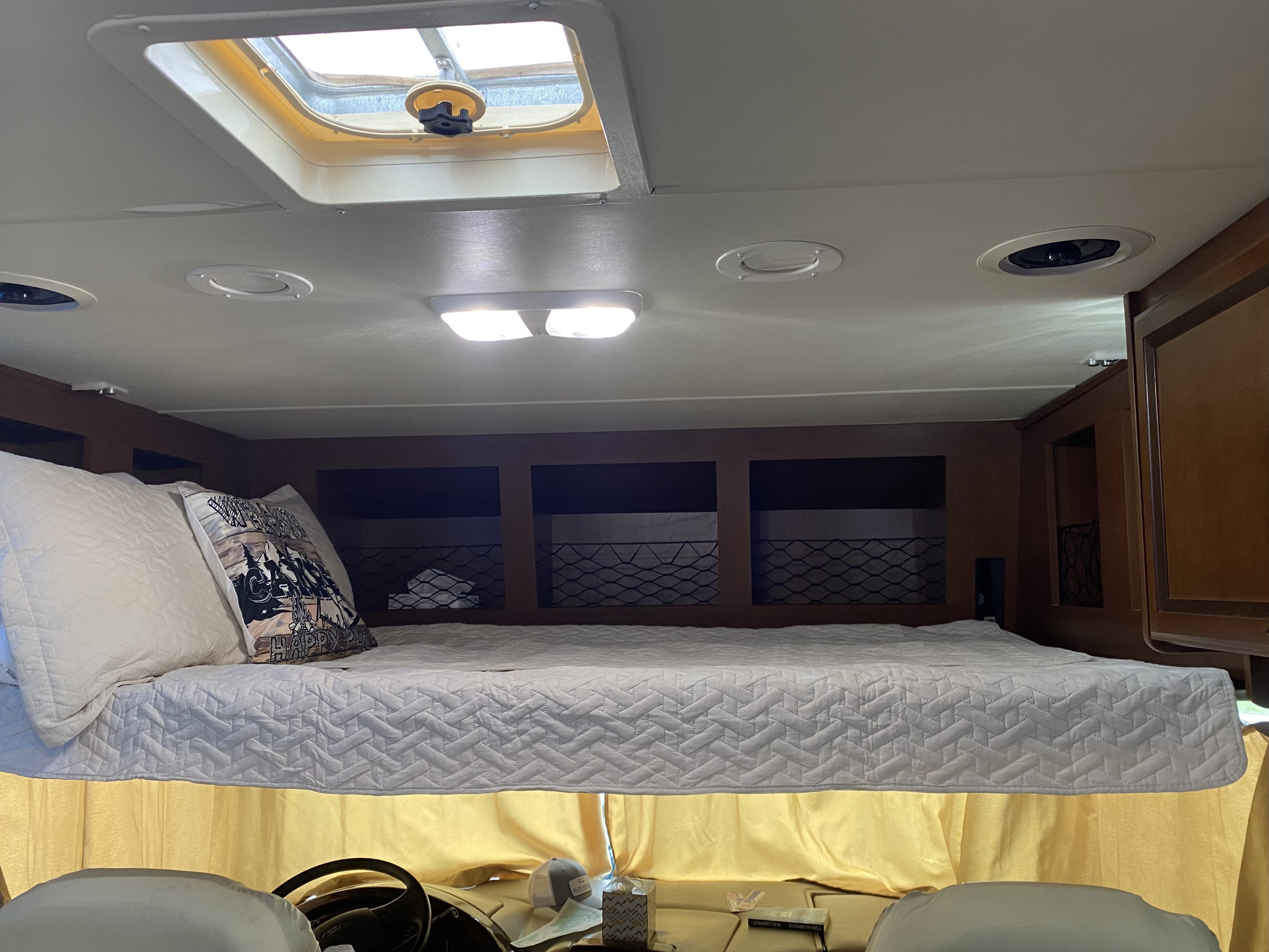 RV rental: View of a well-lit RV interior showing the cab-over bed, skylight, and integrated storage, ideal for travelers.. A.C.E. A.C.E. Motorhome 2014