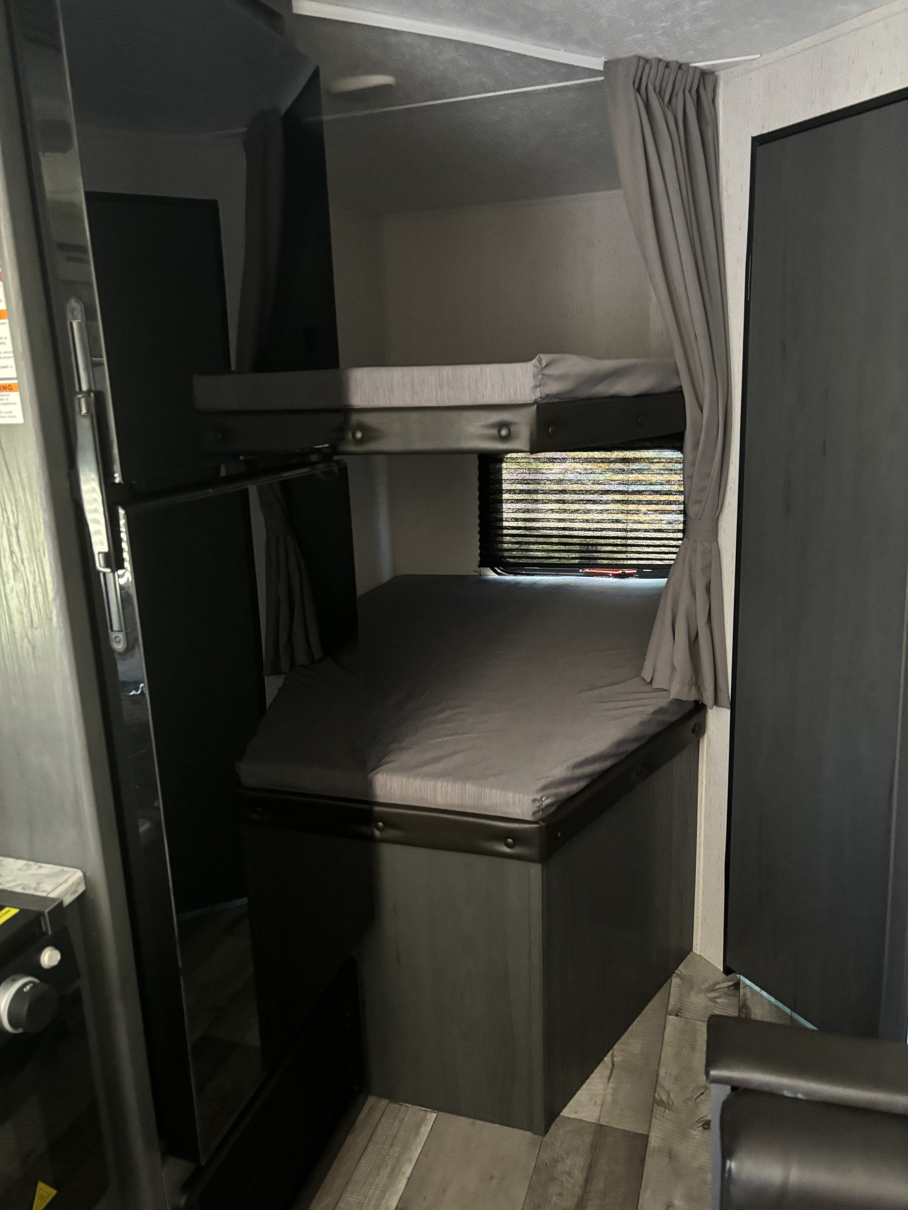 This RV rental features a cozy bunk bed sleeping area with privacy curtains and a window.. Dutchman Aspen Trail LE 2024