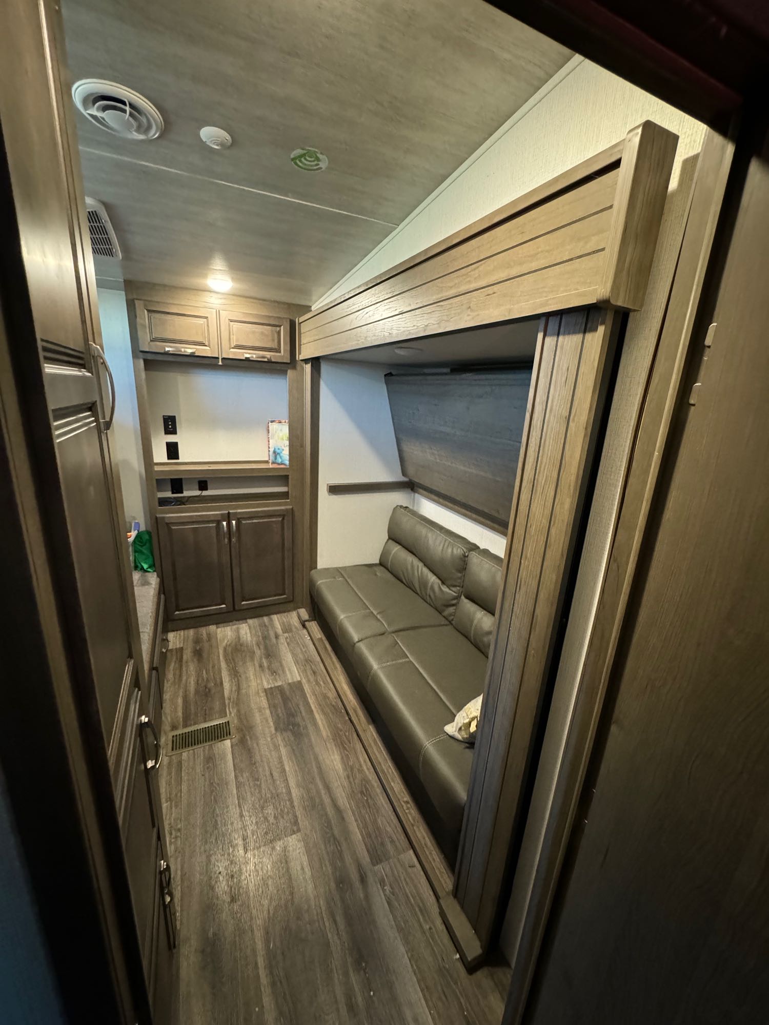 Modern RV rental interior with a cozy sofa and clever fold-down bed, ideal for maximizing living space.. Keystone RV Cougar 2021