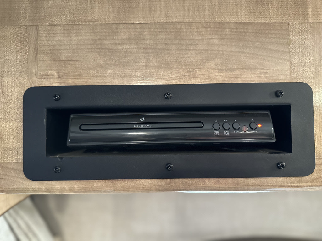This RV rental includes a built-in black DVD/CD player for entertainment, with a red power light on. Essential for road trips.. Coachmen Leprechaun 2019
