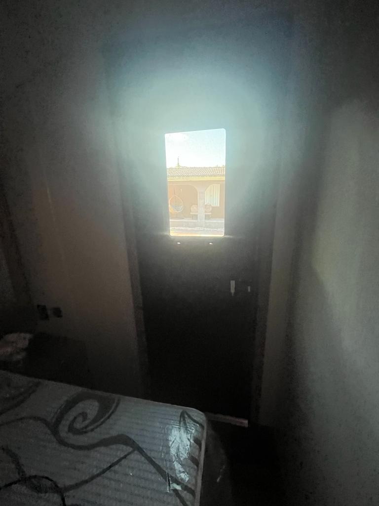 Inside your rv rental: a cozy bed and bright window showing an outdoor view of a building, ideal for travel.. Forest River Cherokee 2023