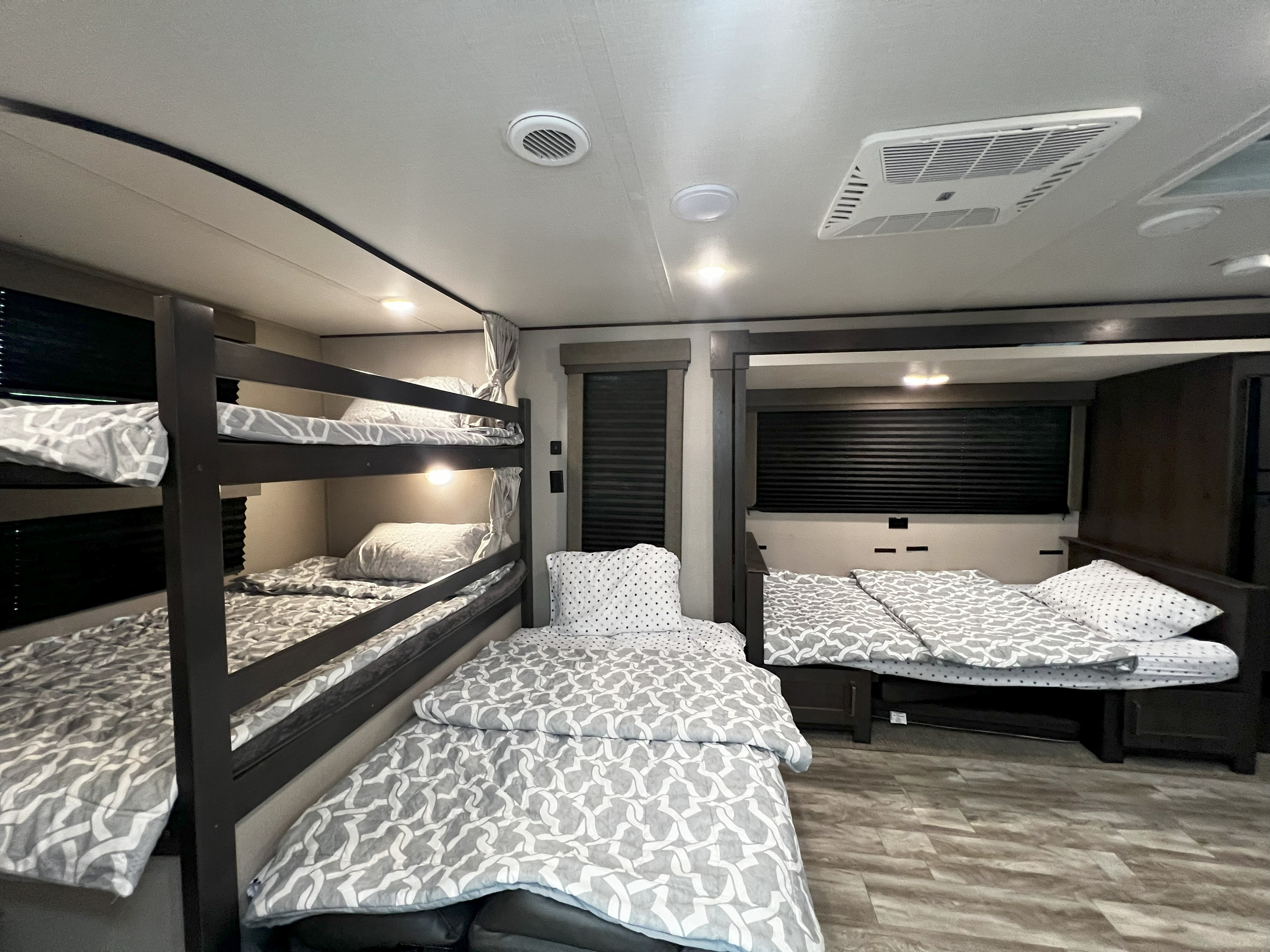 Comfortable RV rental sleeping area featuring bunk beds and two other beds, all with patterned bedding.. Grand Design Transcend Xplor 265BH 2021