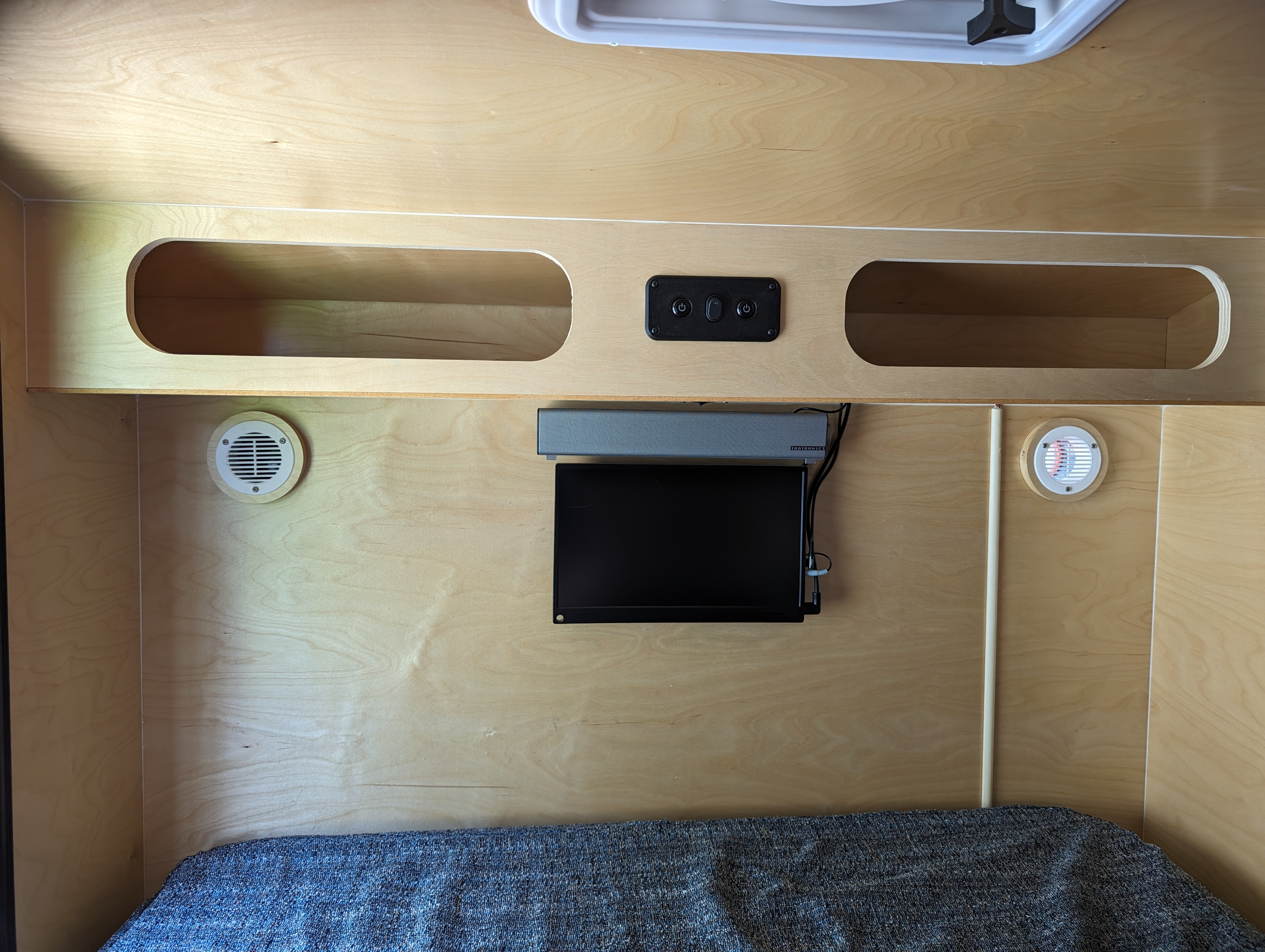RV rental interior: light wood, built-in storage, TV, soundbar, vents, and a comfortable bed.. Hiker Trailer Mid Range 2021