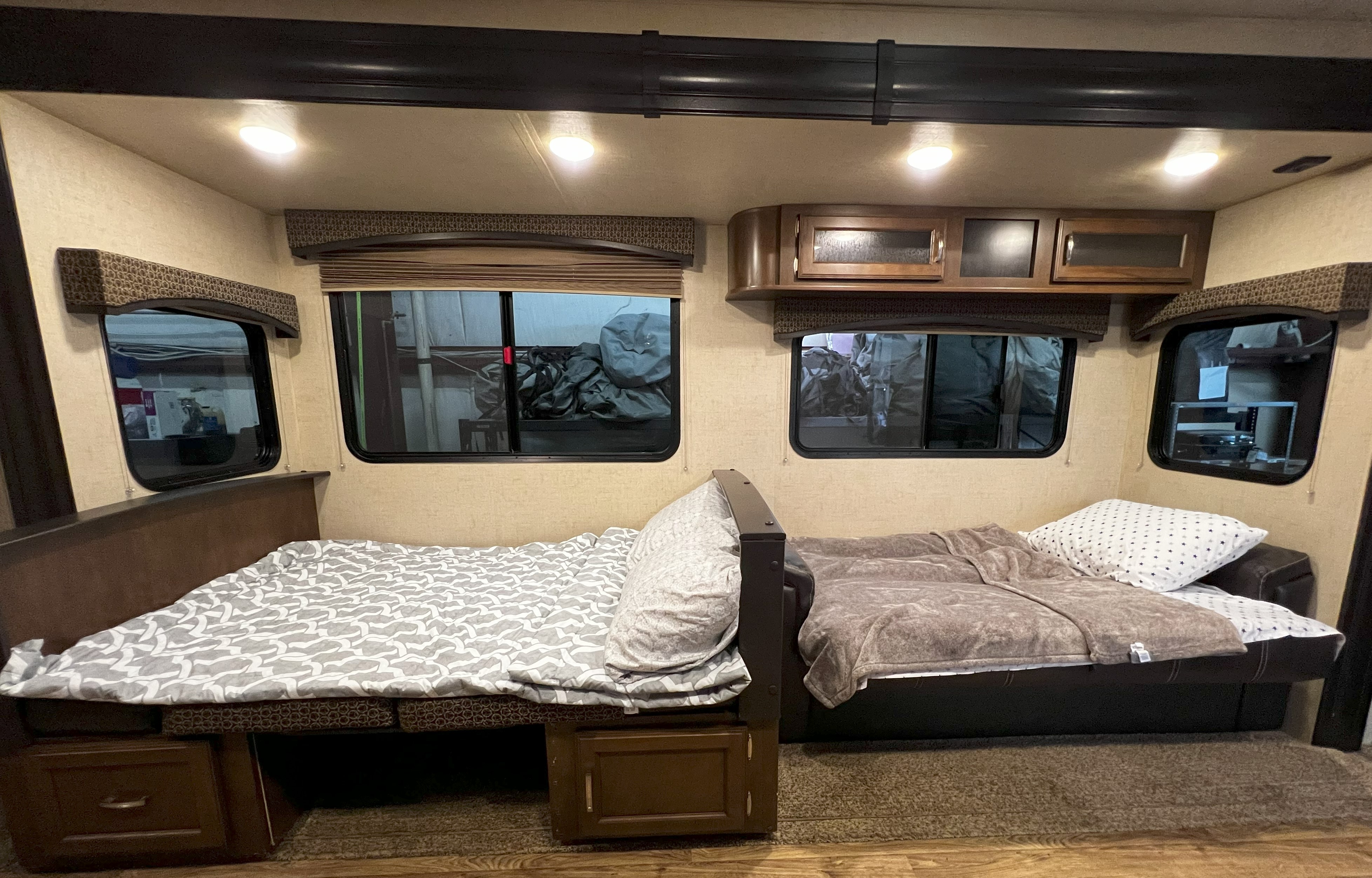 RV rental's cozy interior features two inviting sleeping areas with windows and overhead storage.. Venture Sport Trek 2017
