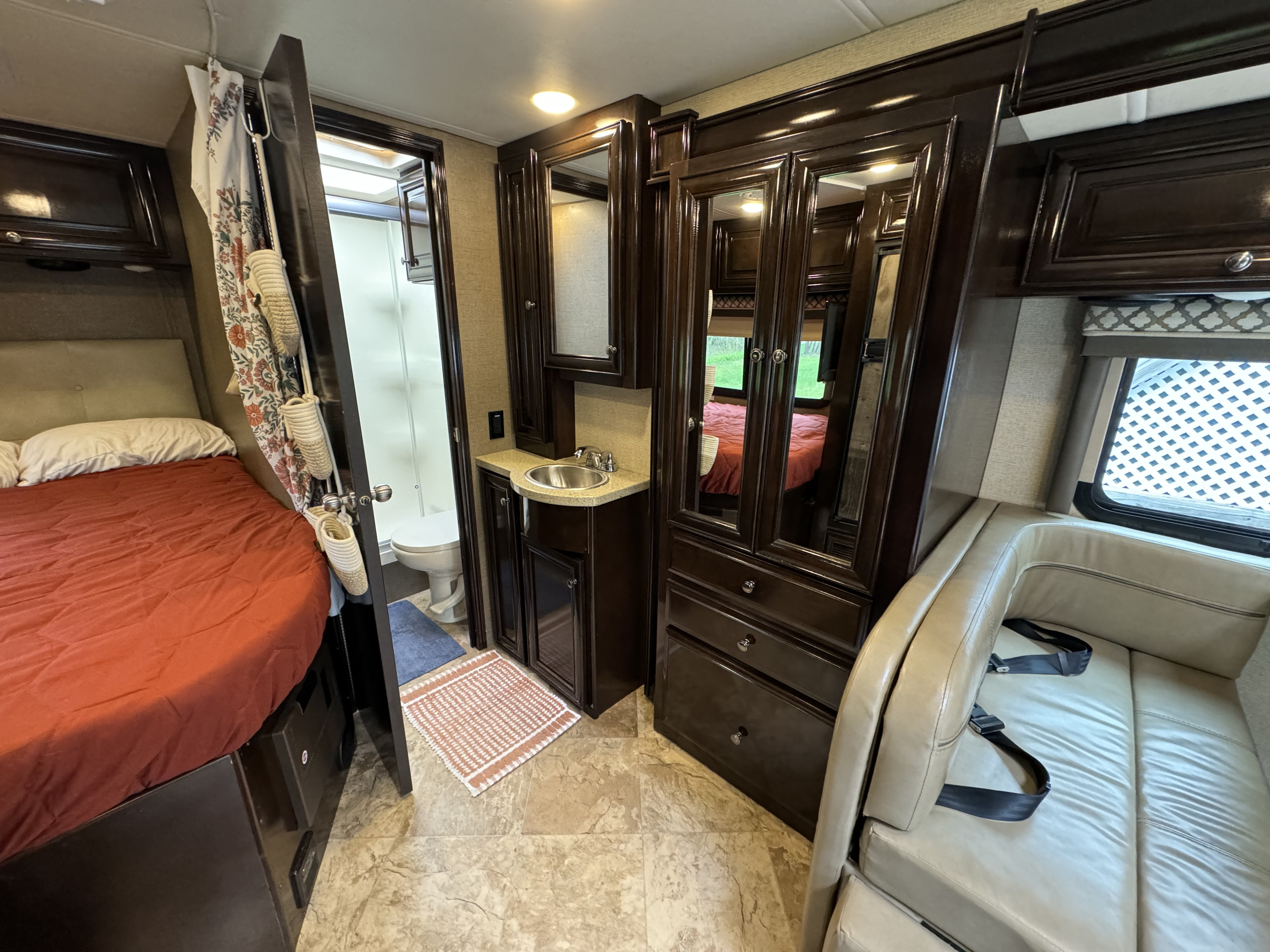 Tour this RV rental's inviting interior: bedroom, full bath, vanity, mirrored closet, and seating area.. Thor Citation Sprinter 2018