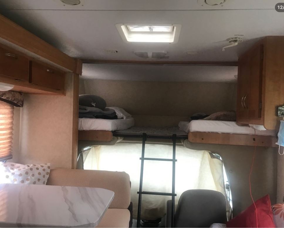 RV rental interior: Overhead bunk beds with ladder, adjacent dining area. Practical layout for travel.. Forest River Sunseeker 2008