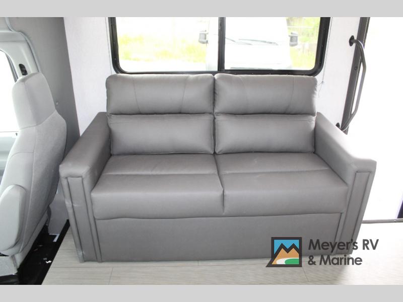 Comfortable gray sofa sleeper in an RV rental interior, ideal for relaxing on your next adventure.. EAST TO WEST ENTRADA 3100FBF 2024