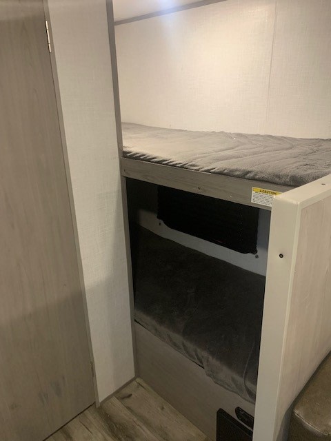 Compact RV rental interior featuring cozy bunk beds for comfortable sleeping. Ideal for families on the go.. Dutchmen Coleman Lantern LT 2022