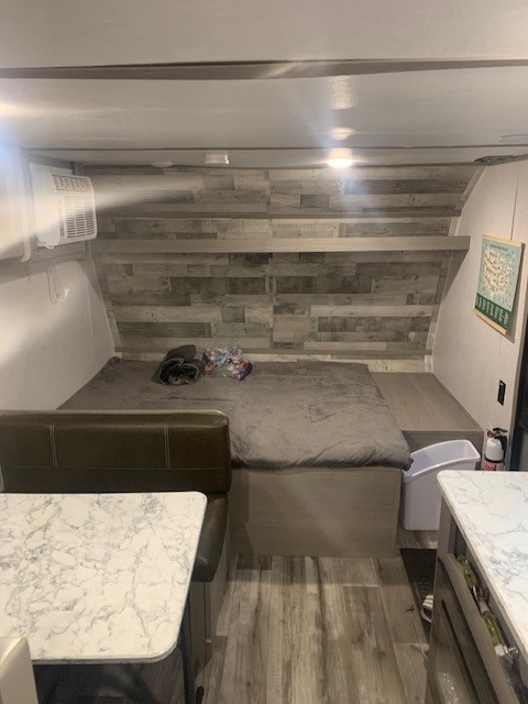 Explore this rv rental's comfy interior featuring a full bed, dinette, and AC, ideal for road trips.. Dutchmen Coleman Lantern LT 2022