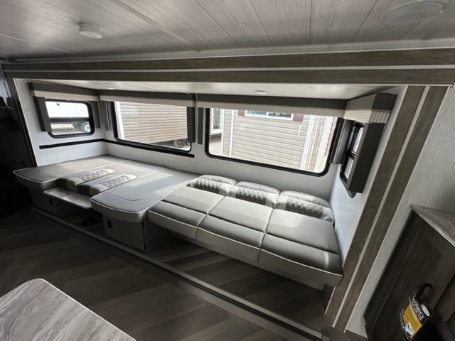 RV rental's spacious interior: A modern, light-gray convertible sofa/bed lines large windows, featuring wood-look flooring.. Salem Cruise Lite 273QBXL 2023