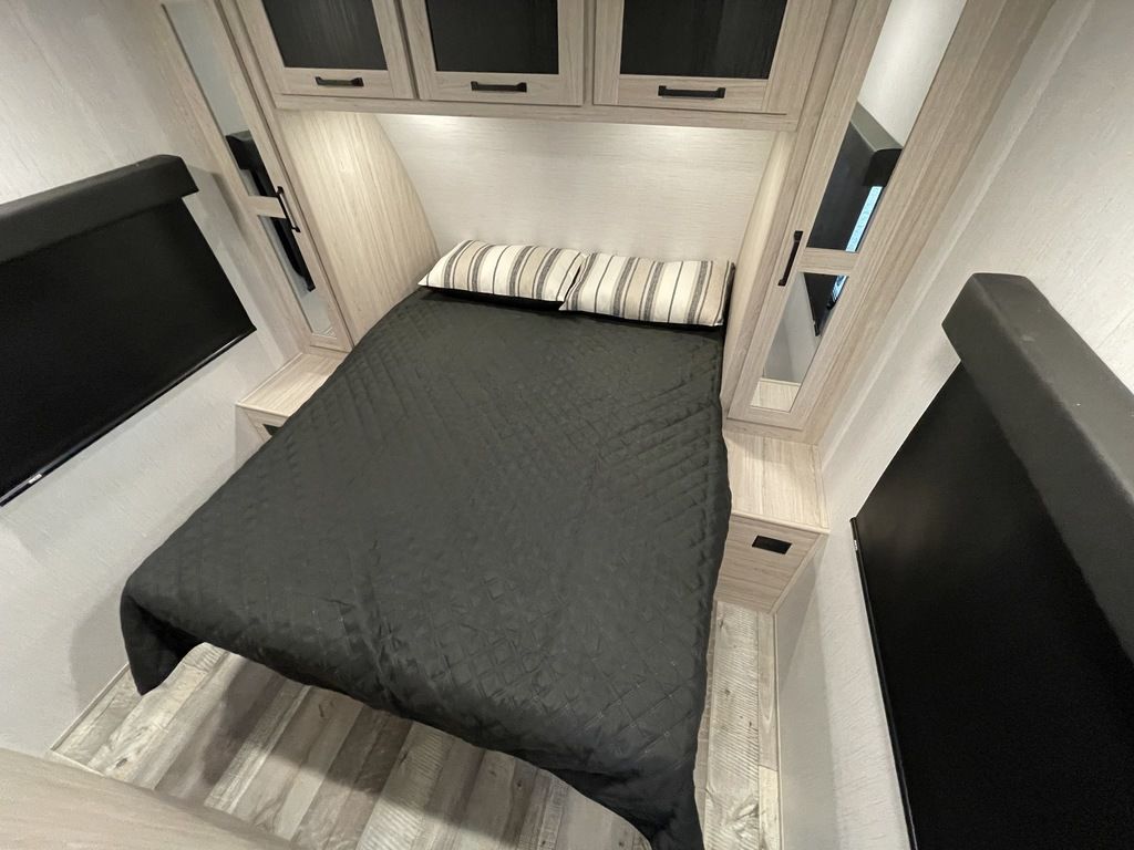 Inviting RV rental bedroom with a comfortable bed, overhead storage, and integrated bedside tables for a cozy stay.. Heartland RVs Sundance Ultra Lite 2022