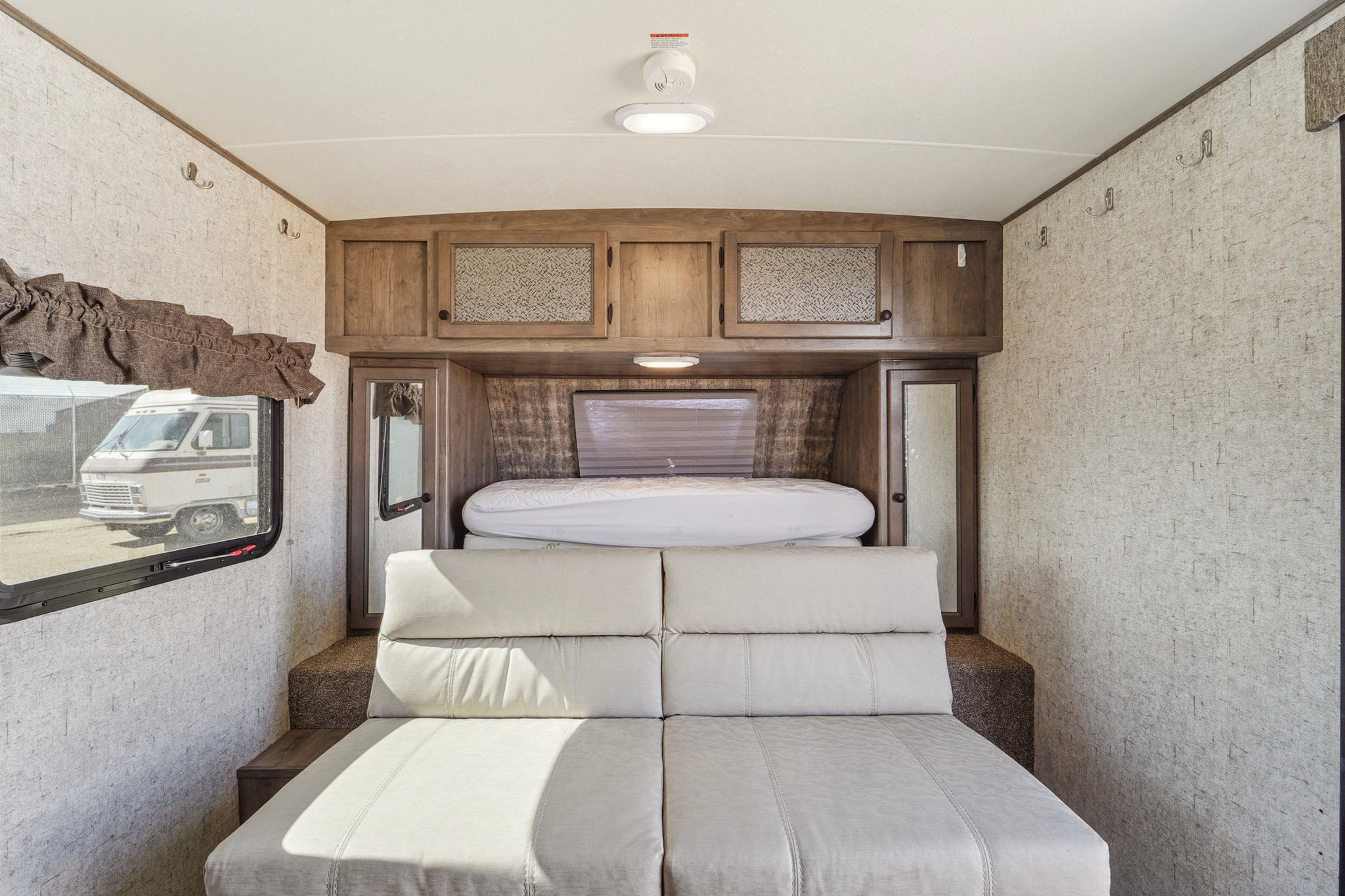Discover the comfortable interior of our RV rental, featuring versatile seating, ample storage, and a cozy sleeping area.. Forest River Coachman Apex 2019