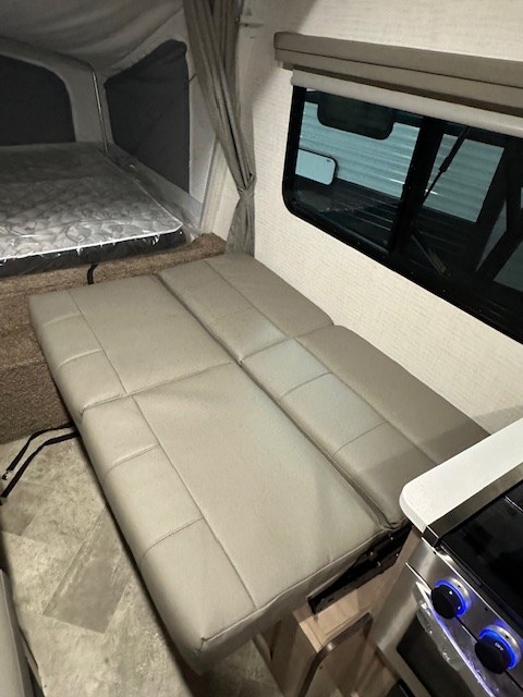 Explore this RV rental's cozy pop-up bed, convertible dinette, and compact kitchen—ideal for adventure.. Solaire 147H 2023