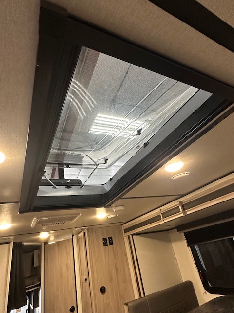 Spacious rv rental interior featuring a large ceiling skylight with mesh screen for ample natural light and ventilation.. Coachmen 2146BHX 2023