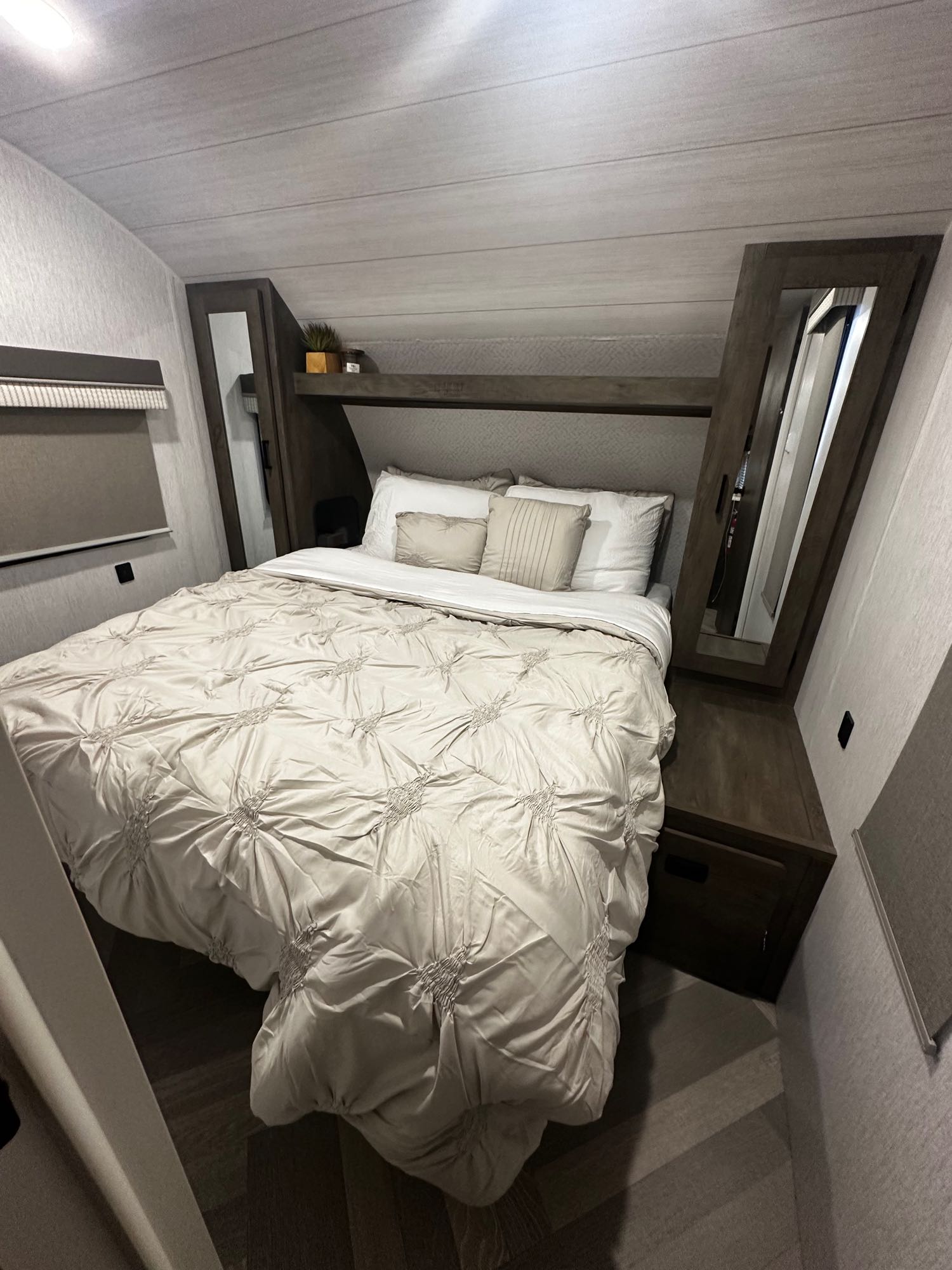 Inviting RV rental bedroom with a large bed, ruched bedding, built-in storage, and light walls.. Forest River Salem Cruise Lite 2022