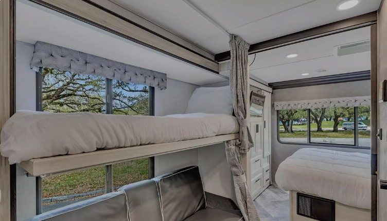 RV rental: Bright interior with bunk beds, main bed, and couch for spacious family RV comfort.. Forest River Sunseeker LE 2022