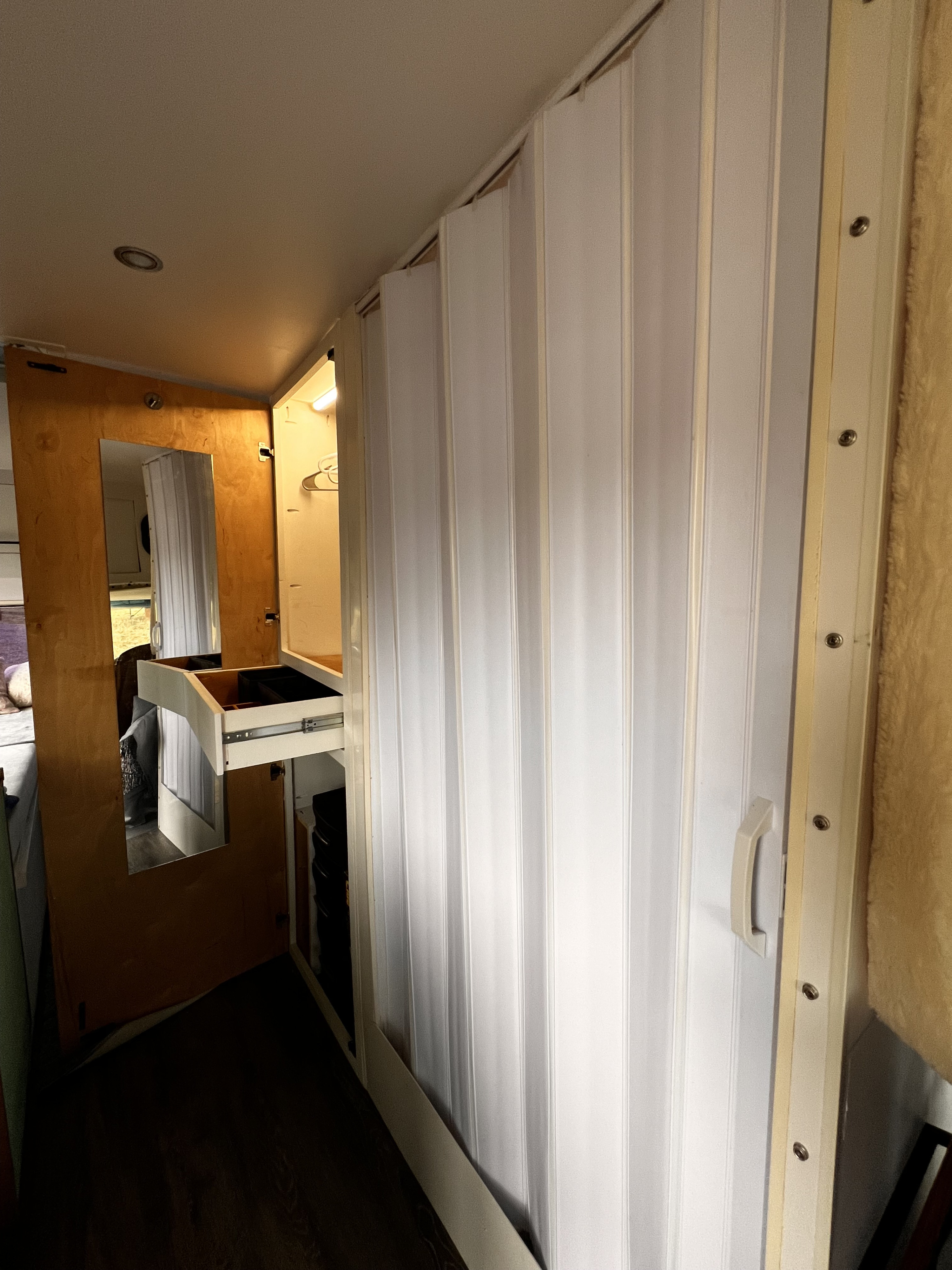 RV rental interior: organized compact closet with mirror, pull-out drawer, and space-saving folding door.. Ford Econoline 1990