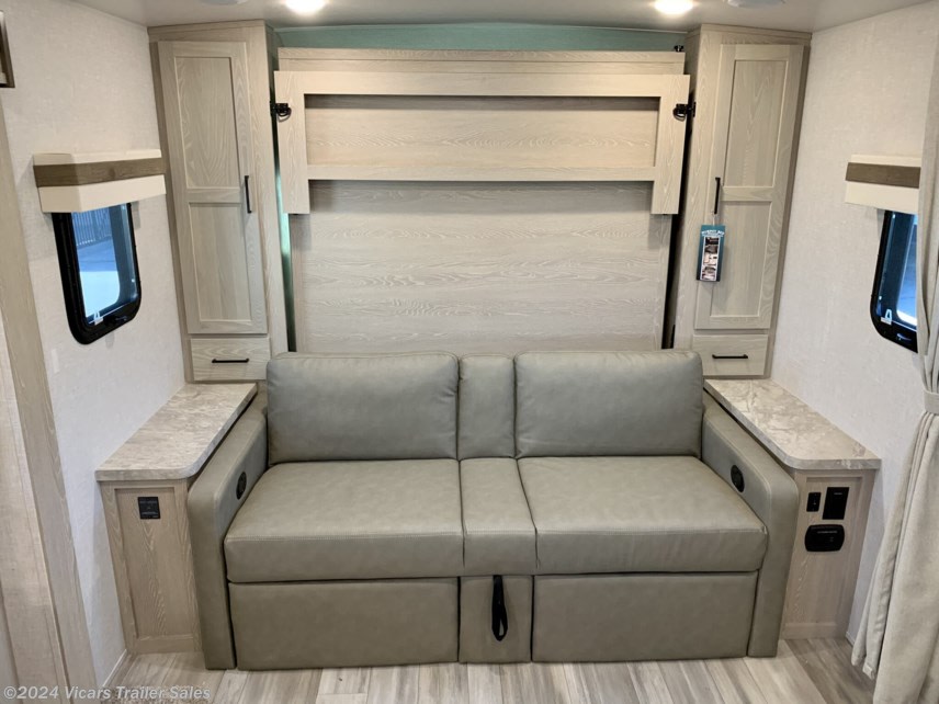 Compact RV rental living area with comfy sofa, fold-down Murphy bed, and built-in storage cabinets.. Forest River Rockwood Mini Lite 2023
