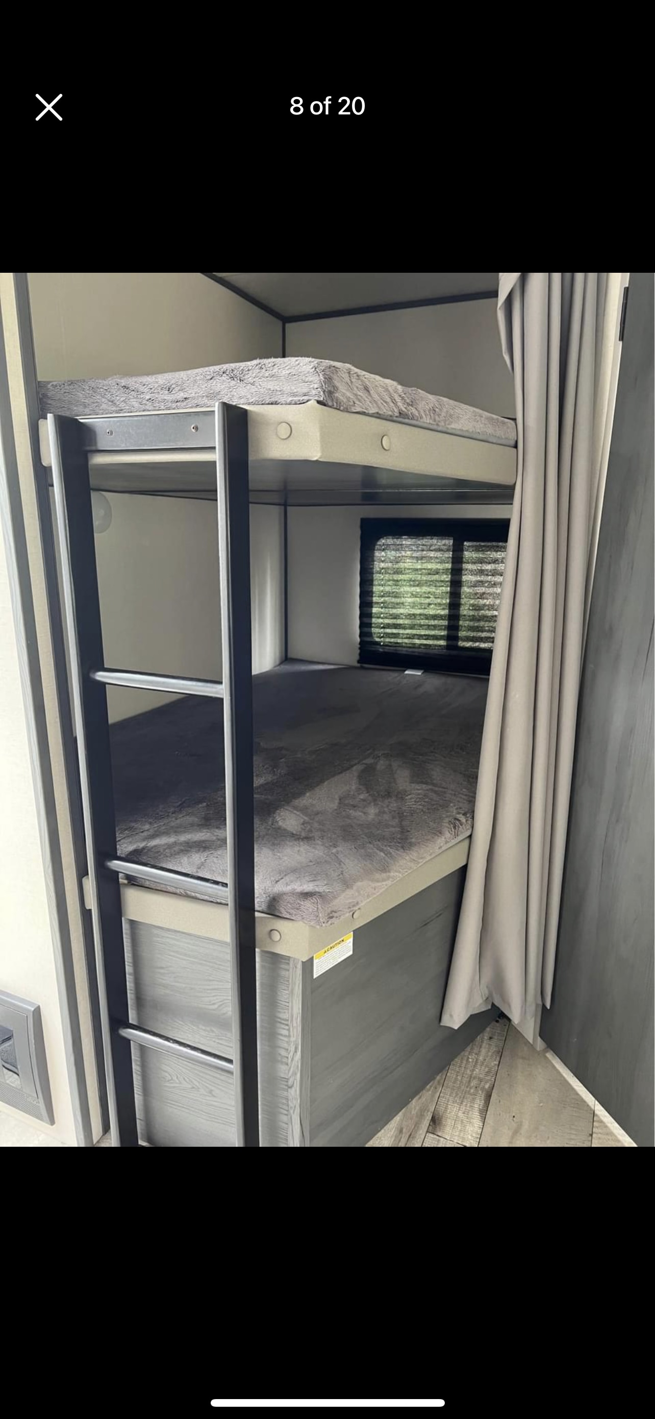 RV rental: two-tier bunk beds with ladder, privacy curtain, and window, providing cozy sleeping for campers.. Colorado Colorado Trailer 2022