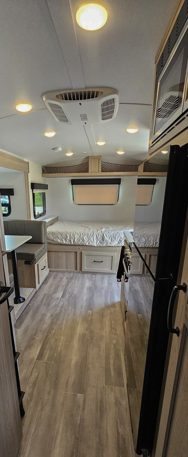 Spacious RV rental interior featuring a bed, dinette, and modern kitchen appliances. Ideal for mobile living.. Forest River Flagstaff E-Pro 2024