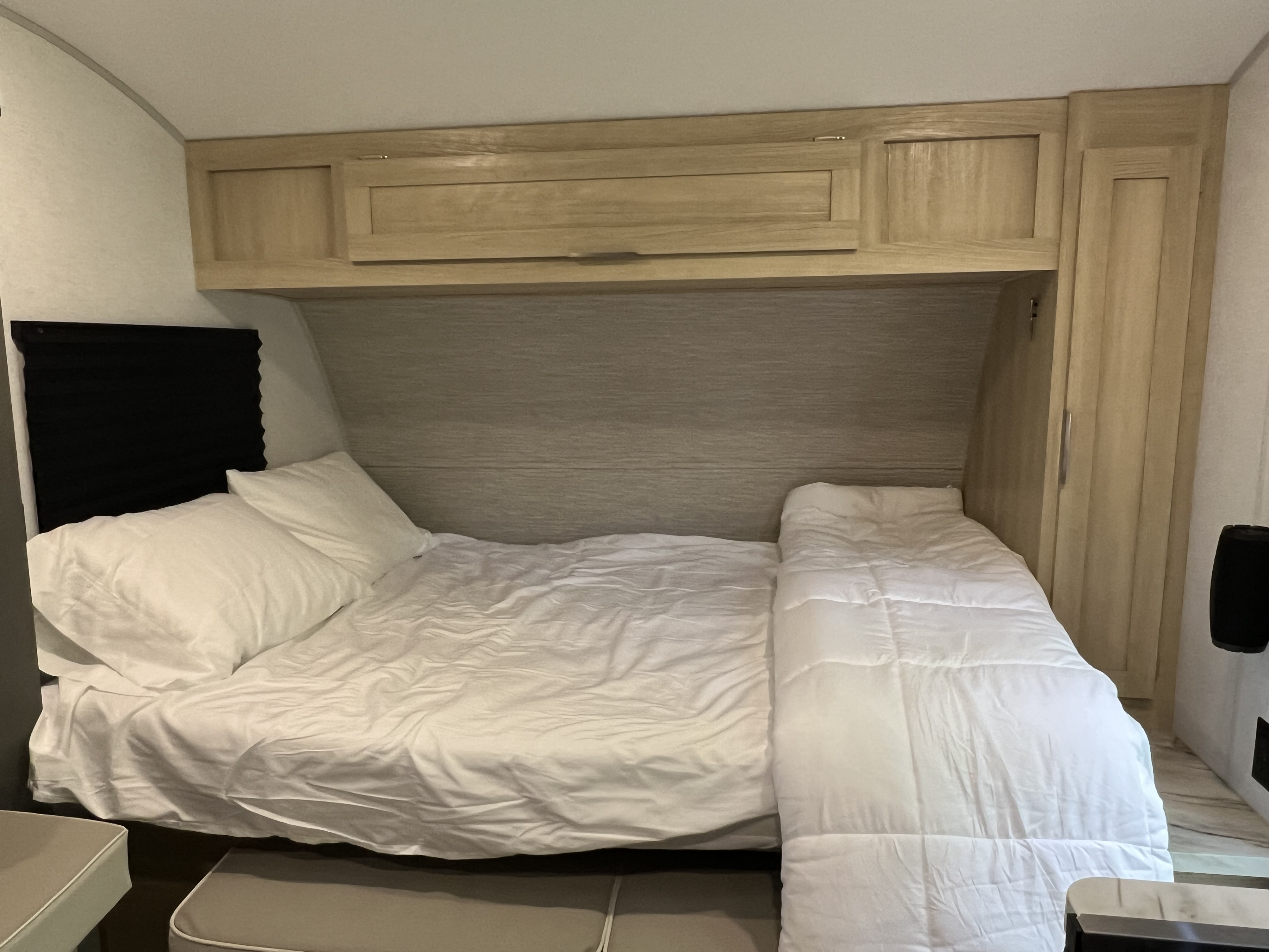 Comfortable RV rental bedroom with white bedding & wood cabinetry.. Forest River Salem FSX 2023