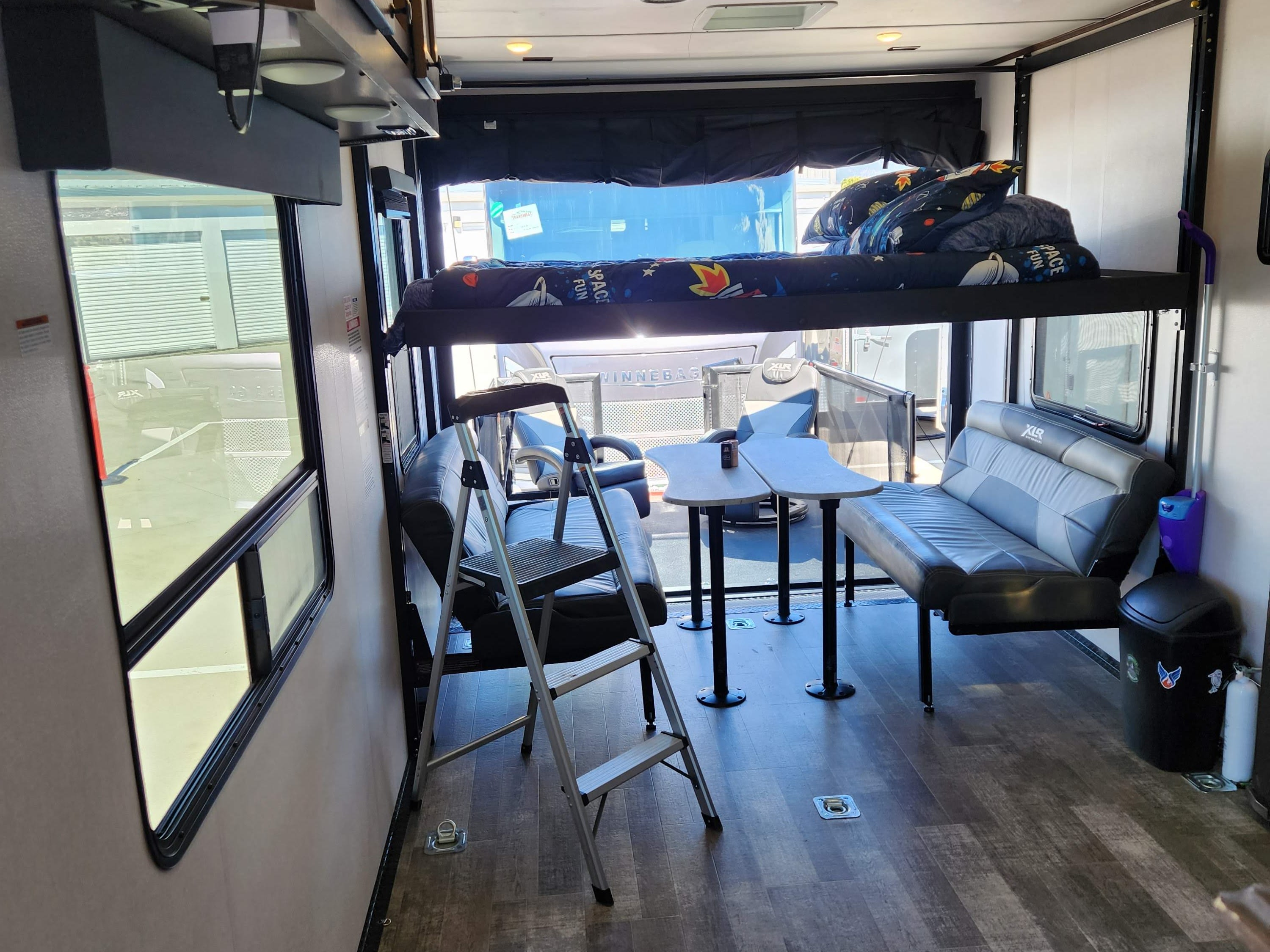 Experience RV rental comfort: toy hauler interior with bunk beds, flexible seating/dining, and utility floor.. Forest River Hyperlite 2815 2022