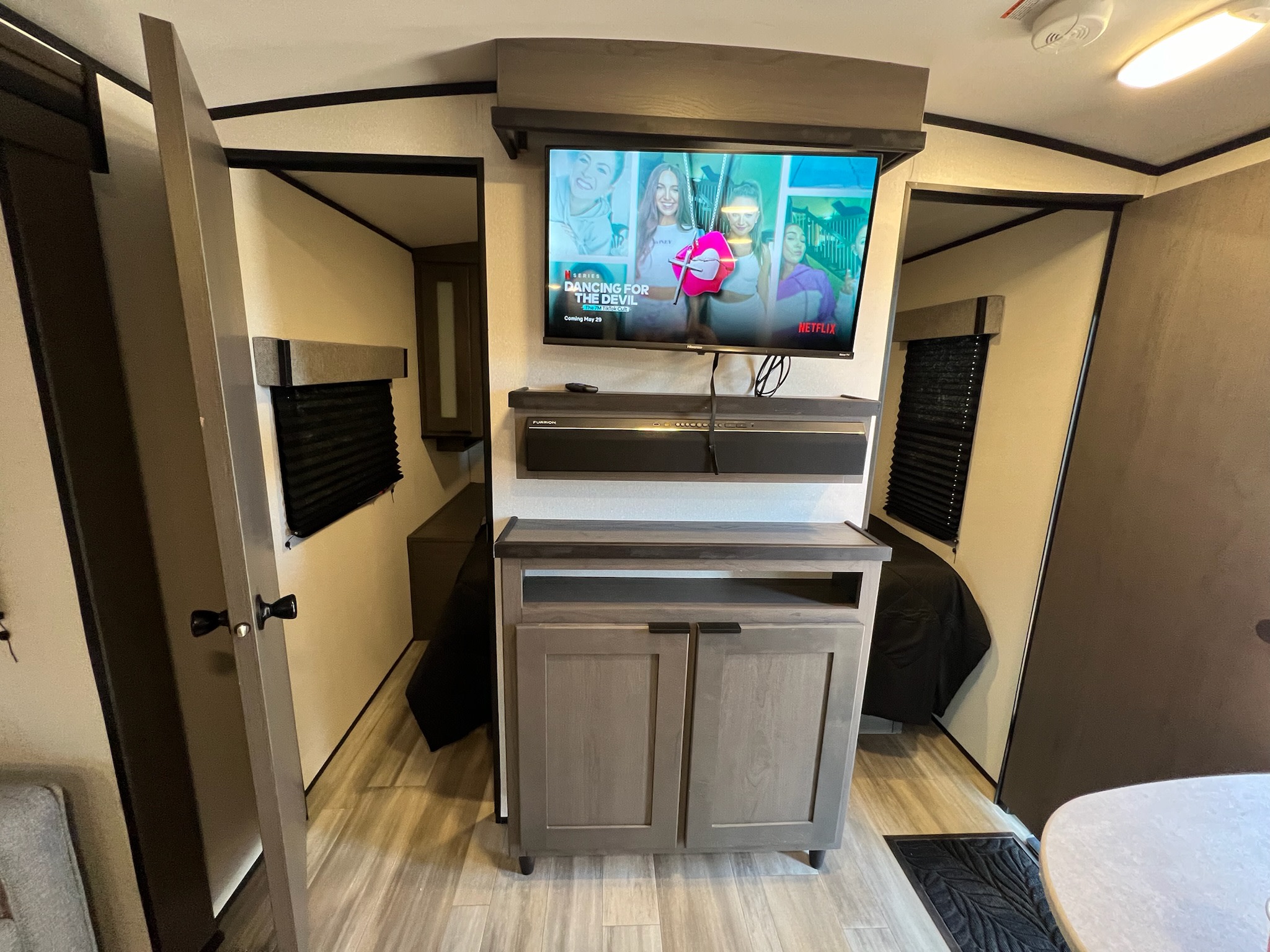 An RV rental interior showing a mounted TV above a media console and cabinet, with bunk beds visible on both sides.. Cruiser RV MPG Ultra Lite 2021