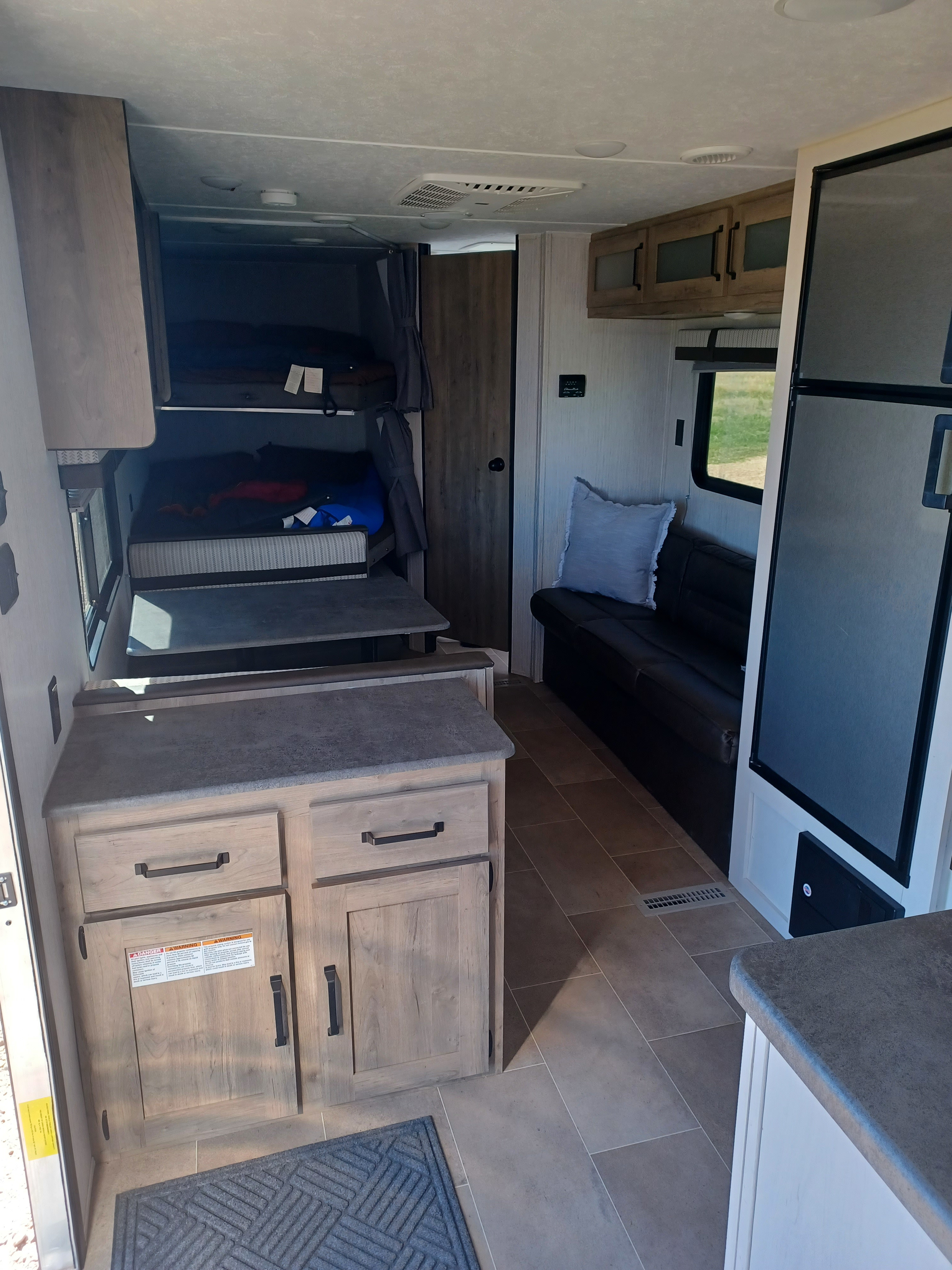 RV rental interior: bright, modern space with bunk beds, sofa seating, and practical kitchen counter.. Forest River Palomino Puma XLE Lite 2021