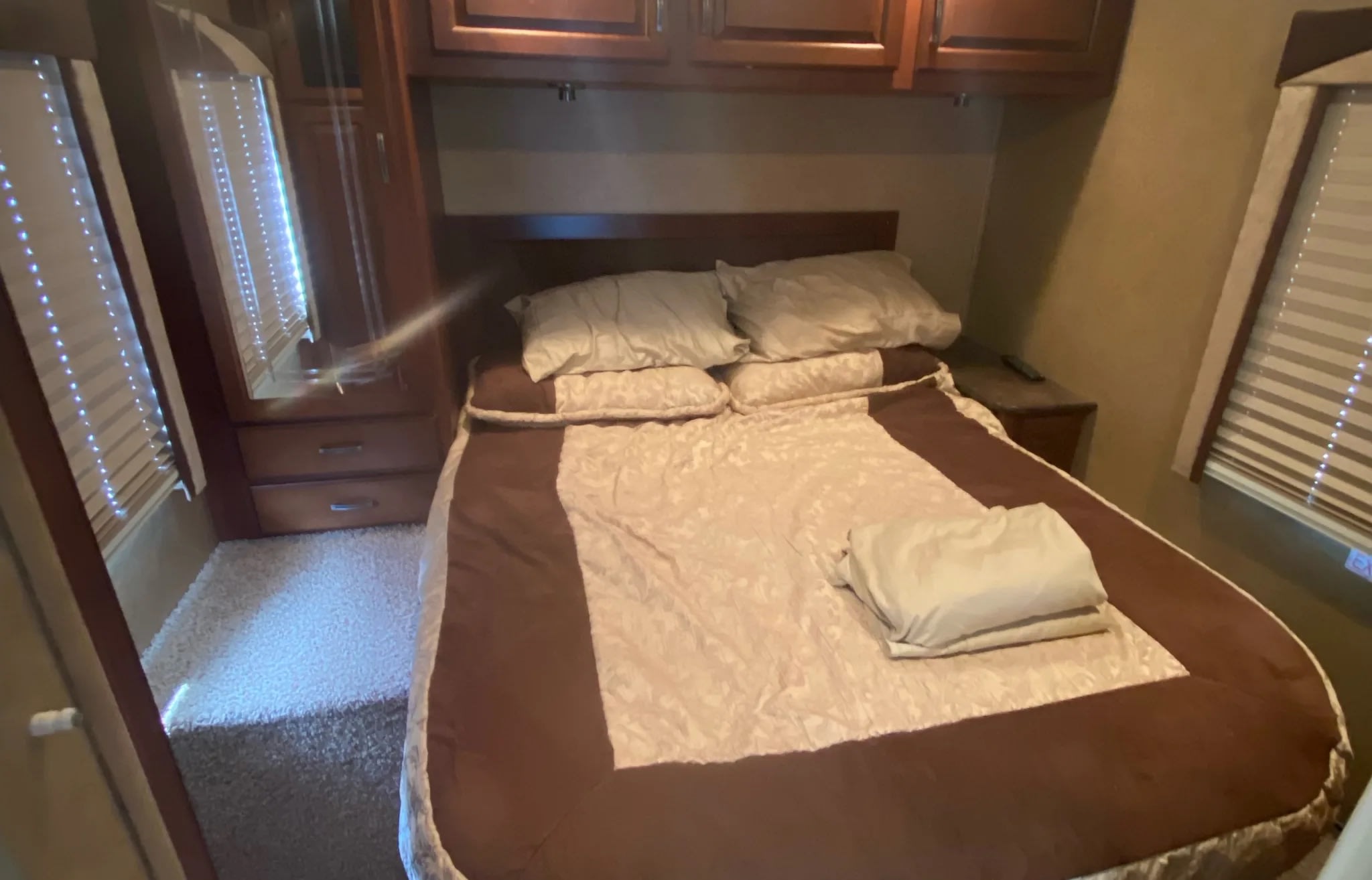 Step into comfort: This RV rental bedroom features a cozy bed, ample storage, and bright window views.. Jayco Greyhawk 2013