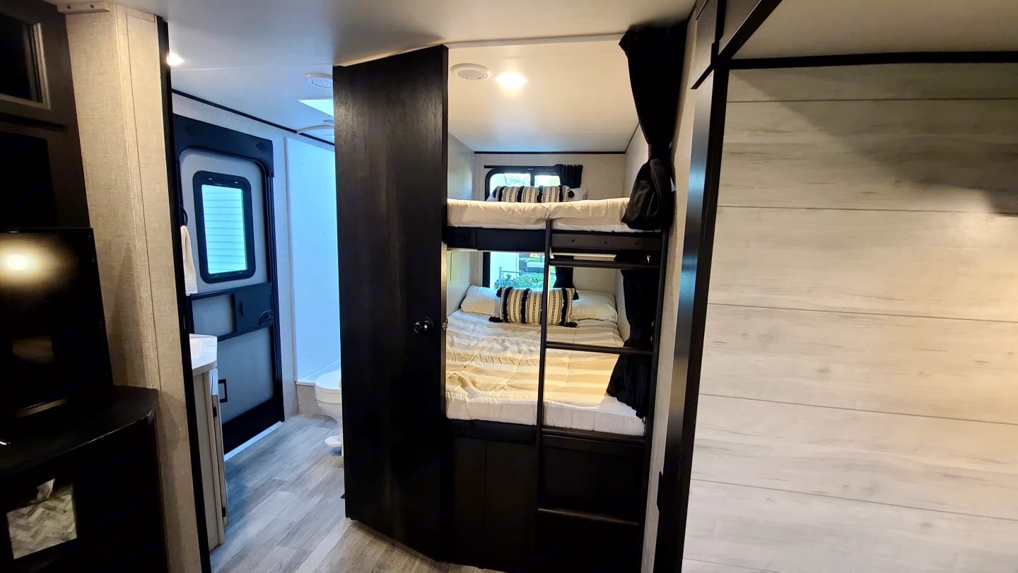 Explore this RV rental's interior: comfy bunk beds, a functional bathroom, and smart living space layout.. Jayco Jay Flight 2023