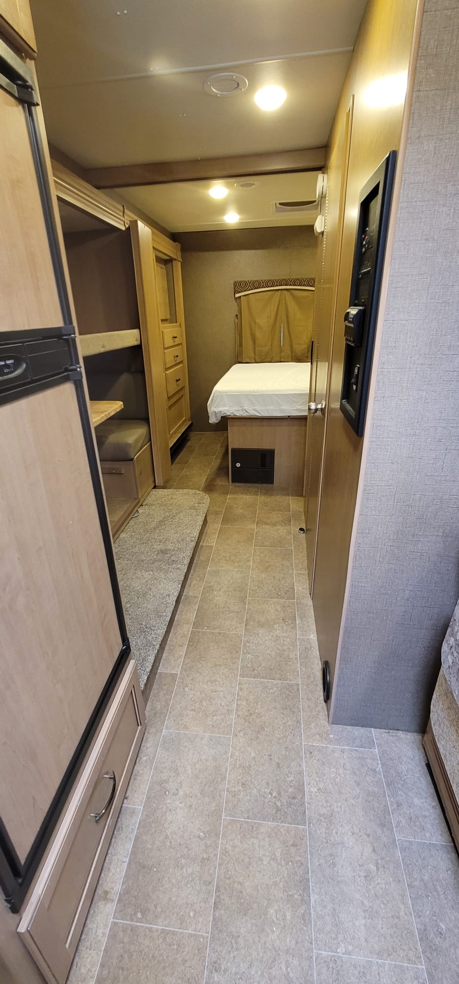 RV rental interior: cozy bedroom, bunk beds, dinette, and fridge in a compact layout. Perfect for travel.. Thor Chateau 2018