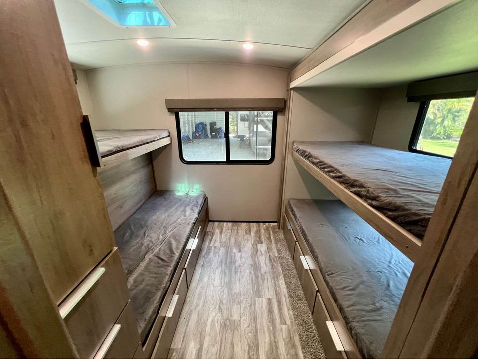 RV rental bunkhouse: two sets of comfy bunk beds with storage drawers, bright interior with windows.. Grand Design Imagine 2020