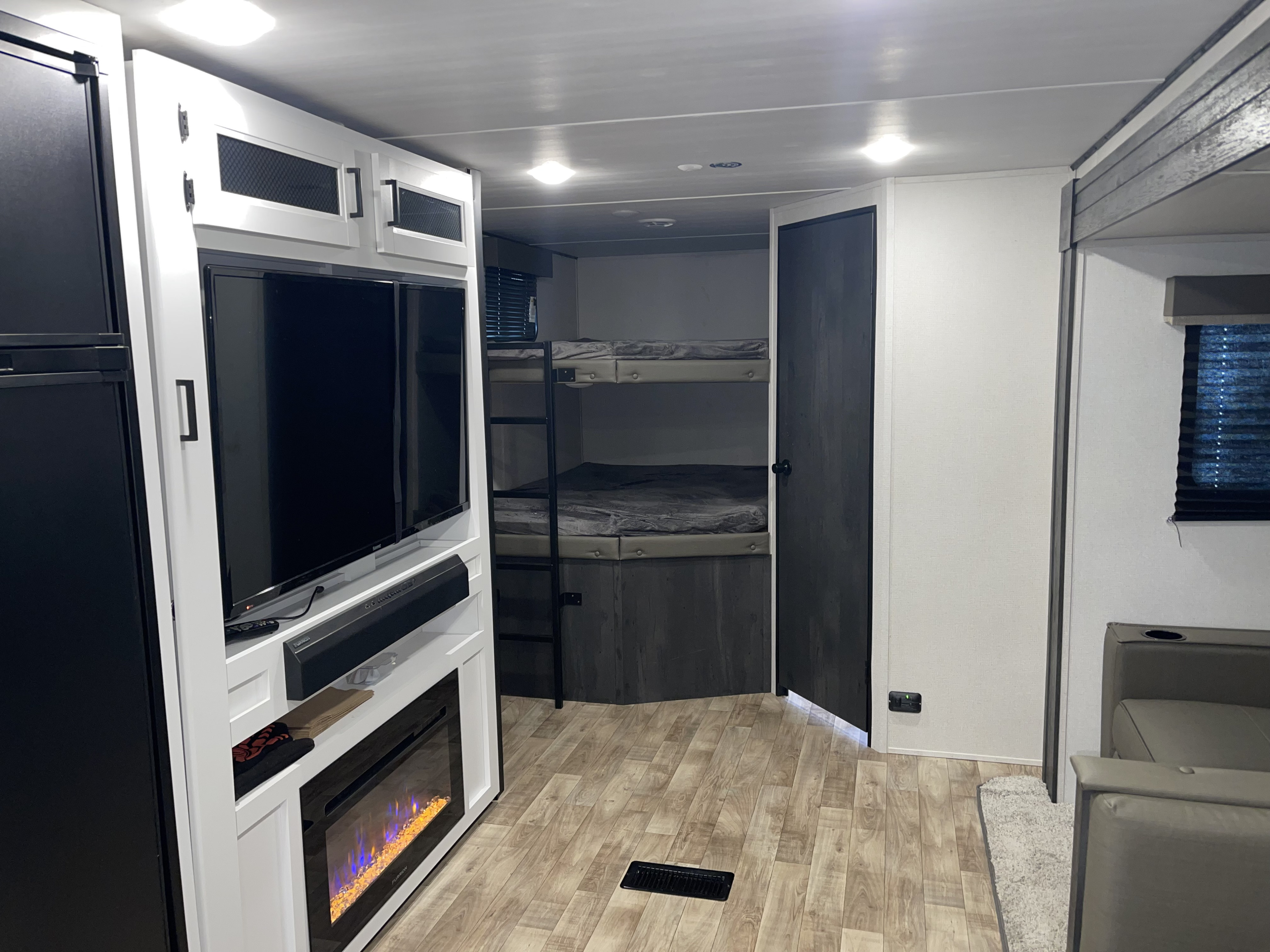 Discover this RV rental's modern interior featuring bunk beds, a TV, fireplace, and comfortable seating area.. Keystone RV Hideout 2022
