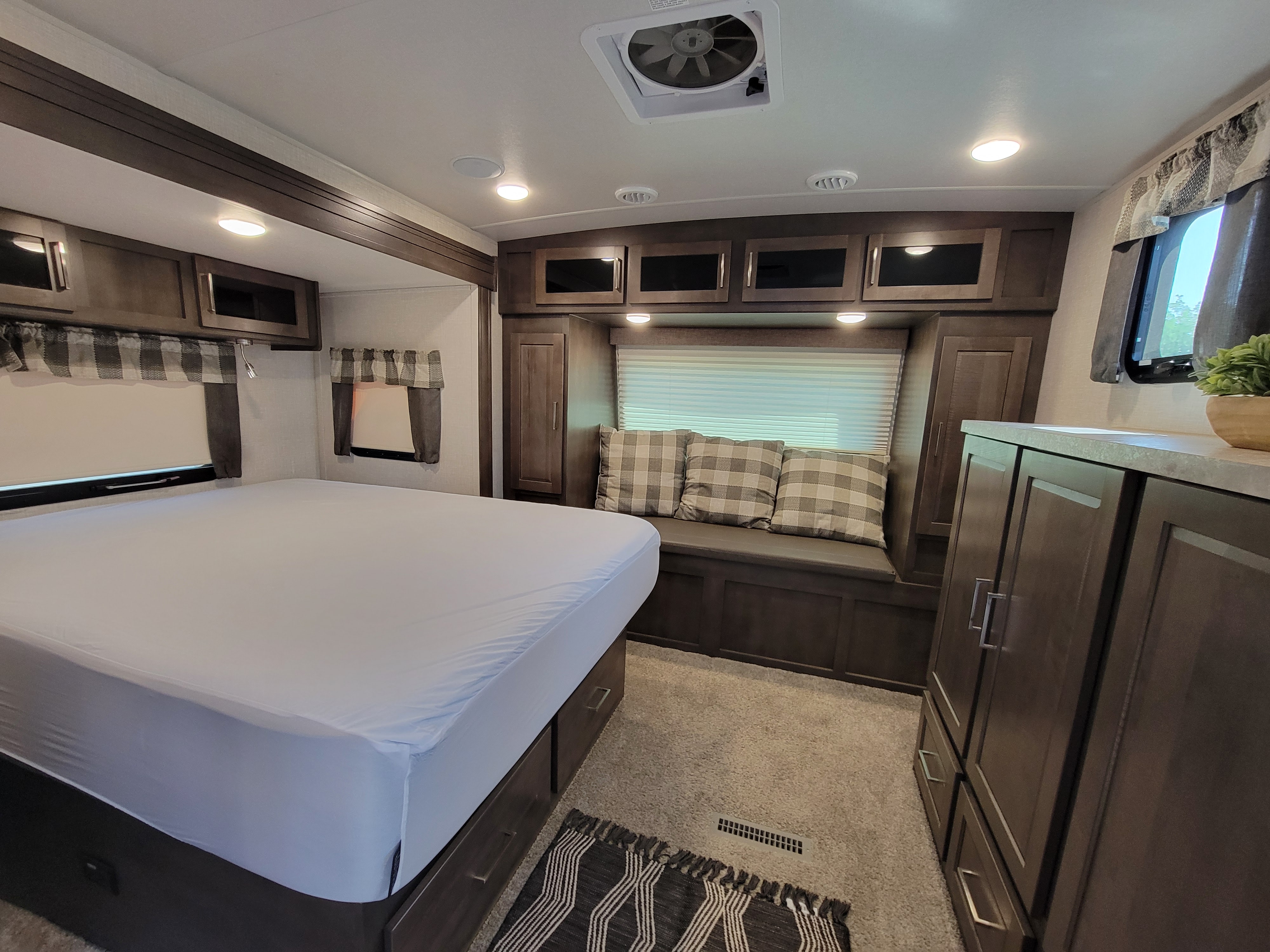 Cozy RV rental bedroom showcasing a comfortable bed, bench seating, and ample storage for your next adventure.. Forest River Flagstaff Super Lite 2021