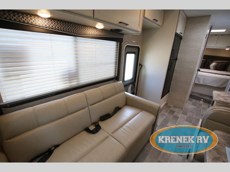 Explore a comfortable RV rental: spacious living area with a sofa, large window, kitchen, and bedroom access.. Thor Chateau 2022