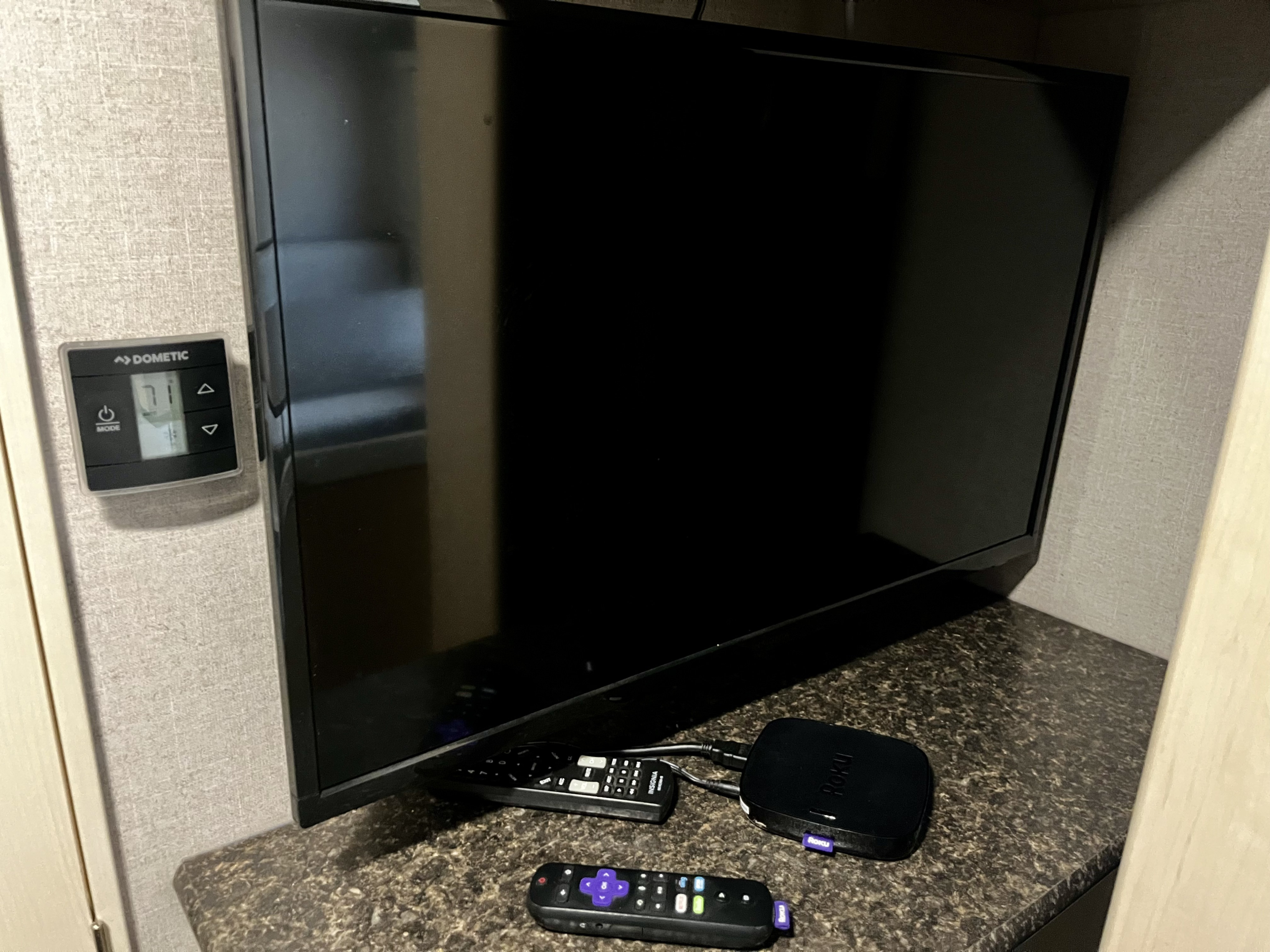 RV rental living area with a TV, Roku, remotes, and a Dometic thermostat set to 71, offering entertainment and climate control.. Winnebago Micro Mini- 2108DS 2020