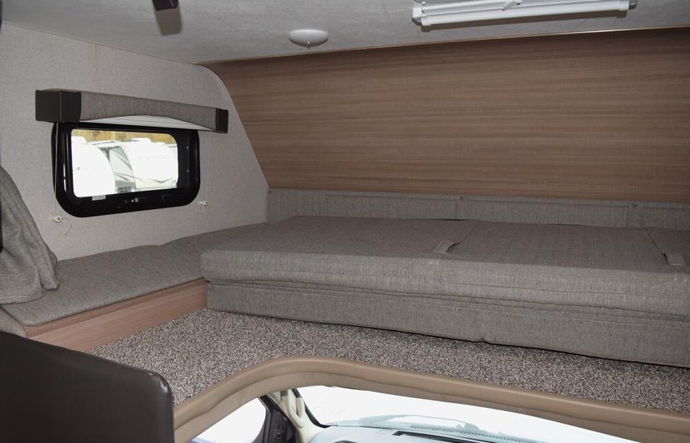 RV rental bunk area with comfortable bed cushions, side bench, and window in a modern interior.. Adventurer Adventurer 2020