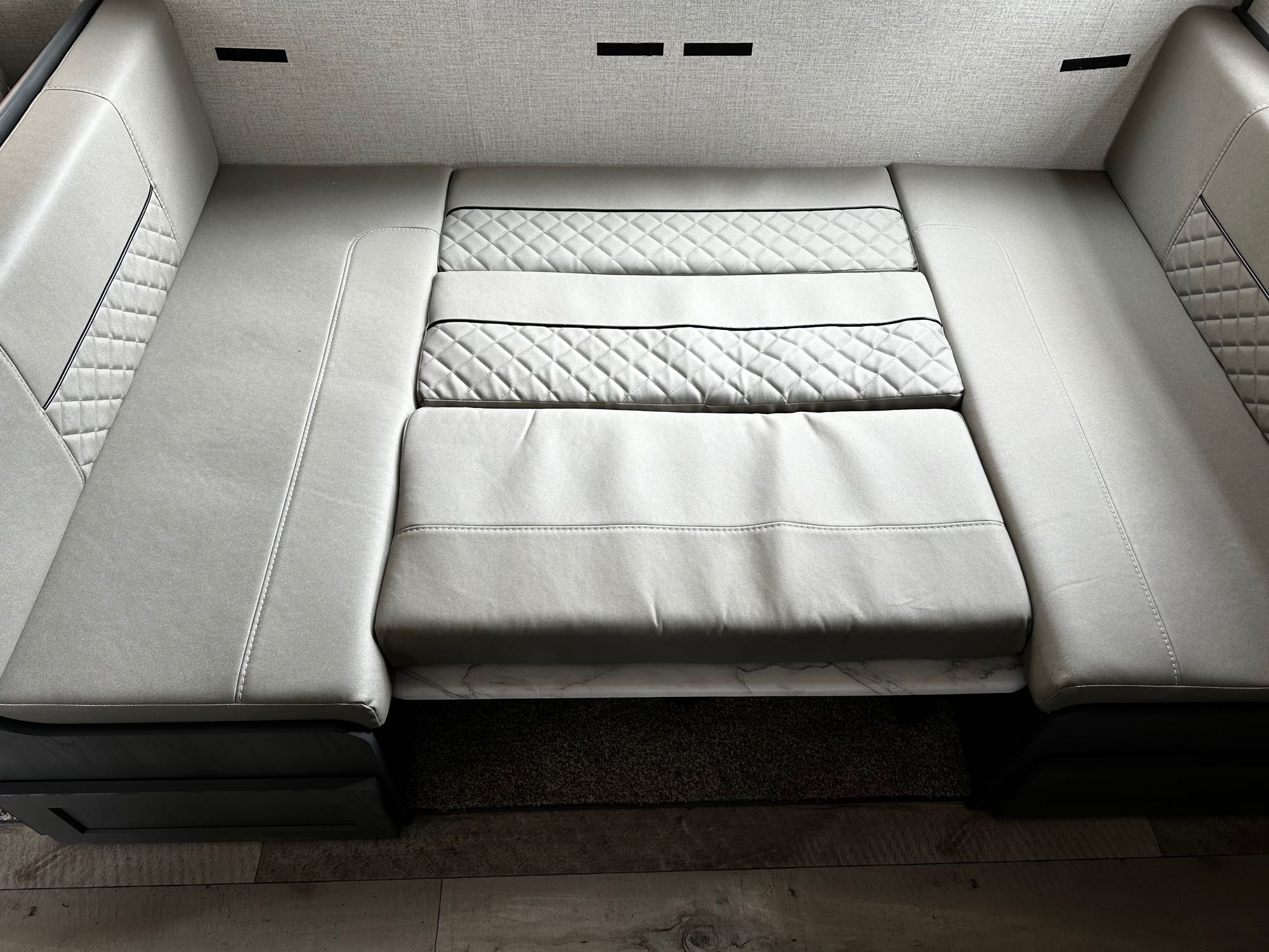 RV rental interior: light gray convertible dinette with quilted cushions, perfect for lounging or an extra bed.. Aspen Trail Aspen Trail Trailer 2022